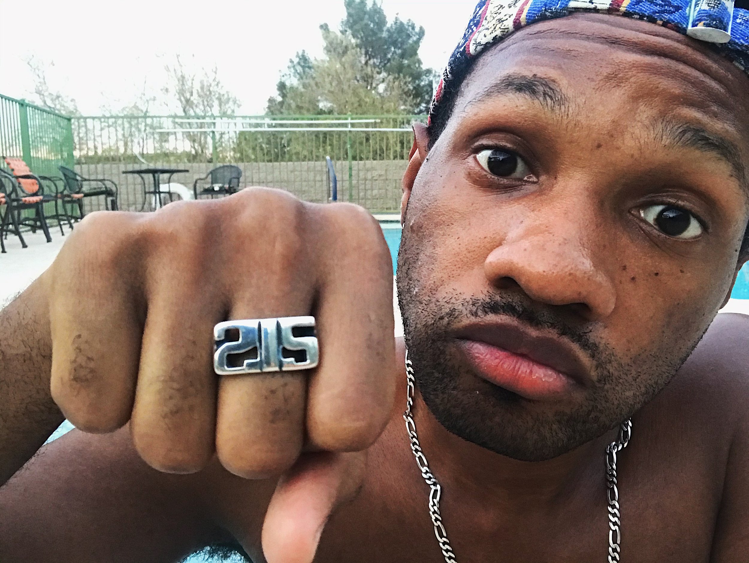 Male Model wearing sterling silver ring with wide band and a large motif depicting 215 in a bold font with oxidized details.