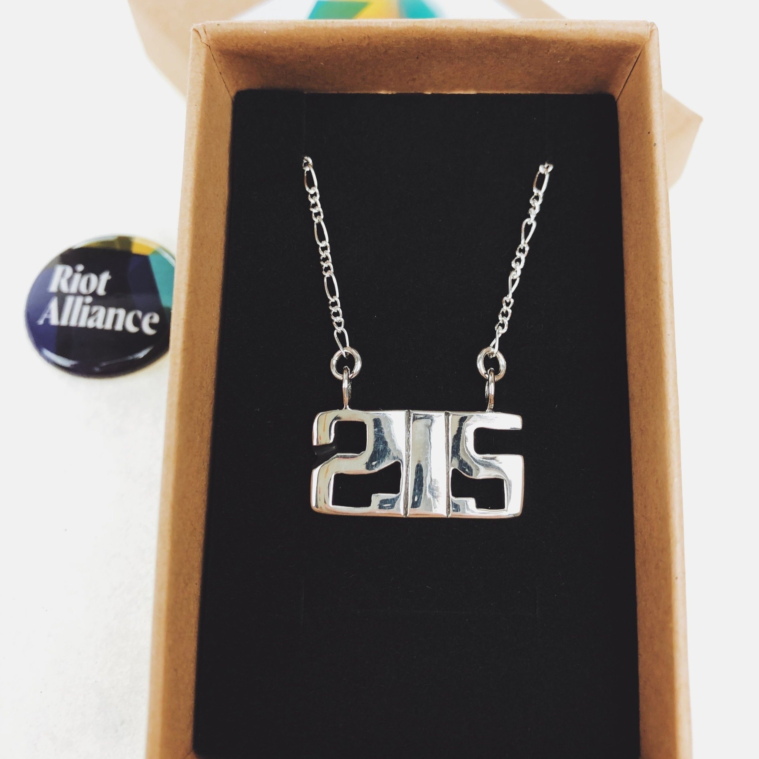 Close-up of sterling silver 215 necklace shown in packaging.