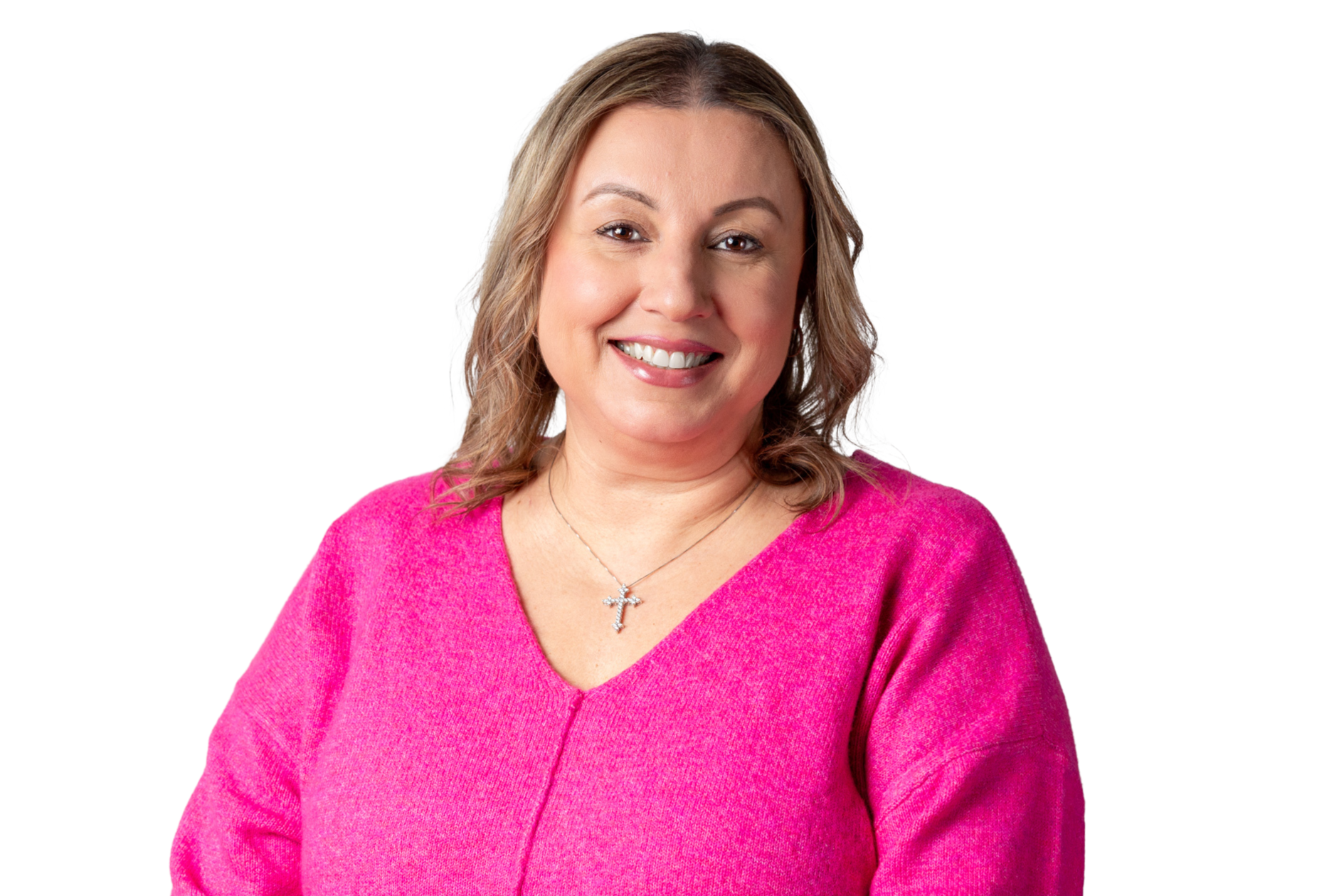 Portrait of a woman smiling, wearing a pink sweater and a cross necklace, against a white background.