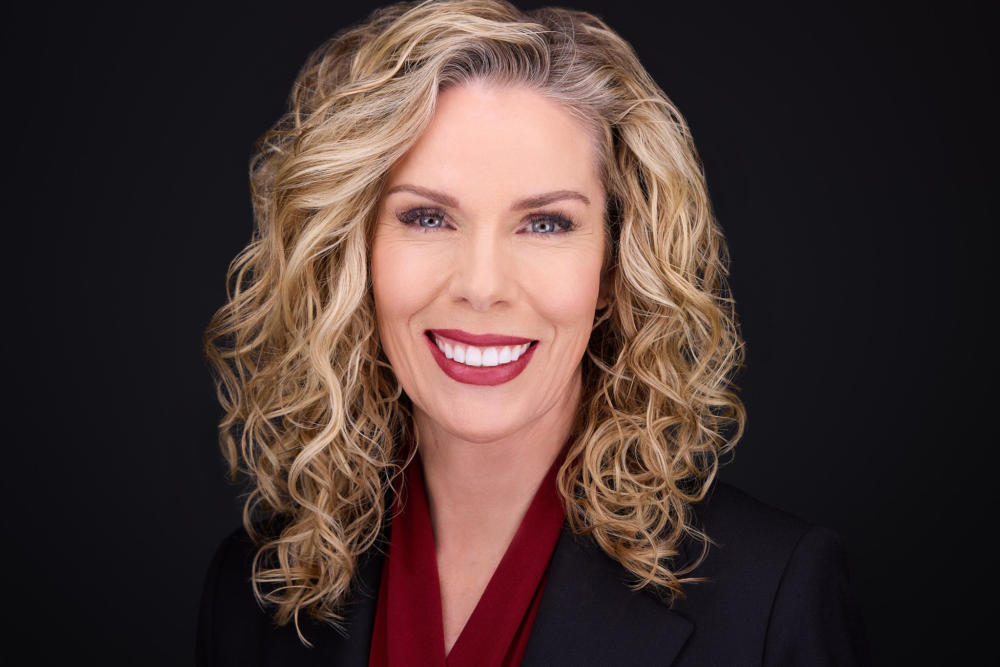 Professional headshot with a warm, approachable expression.