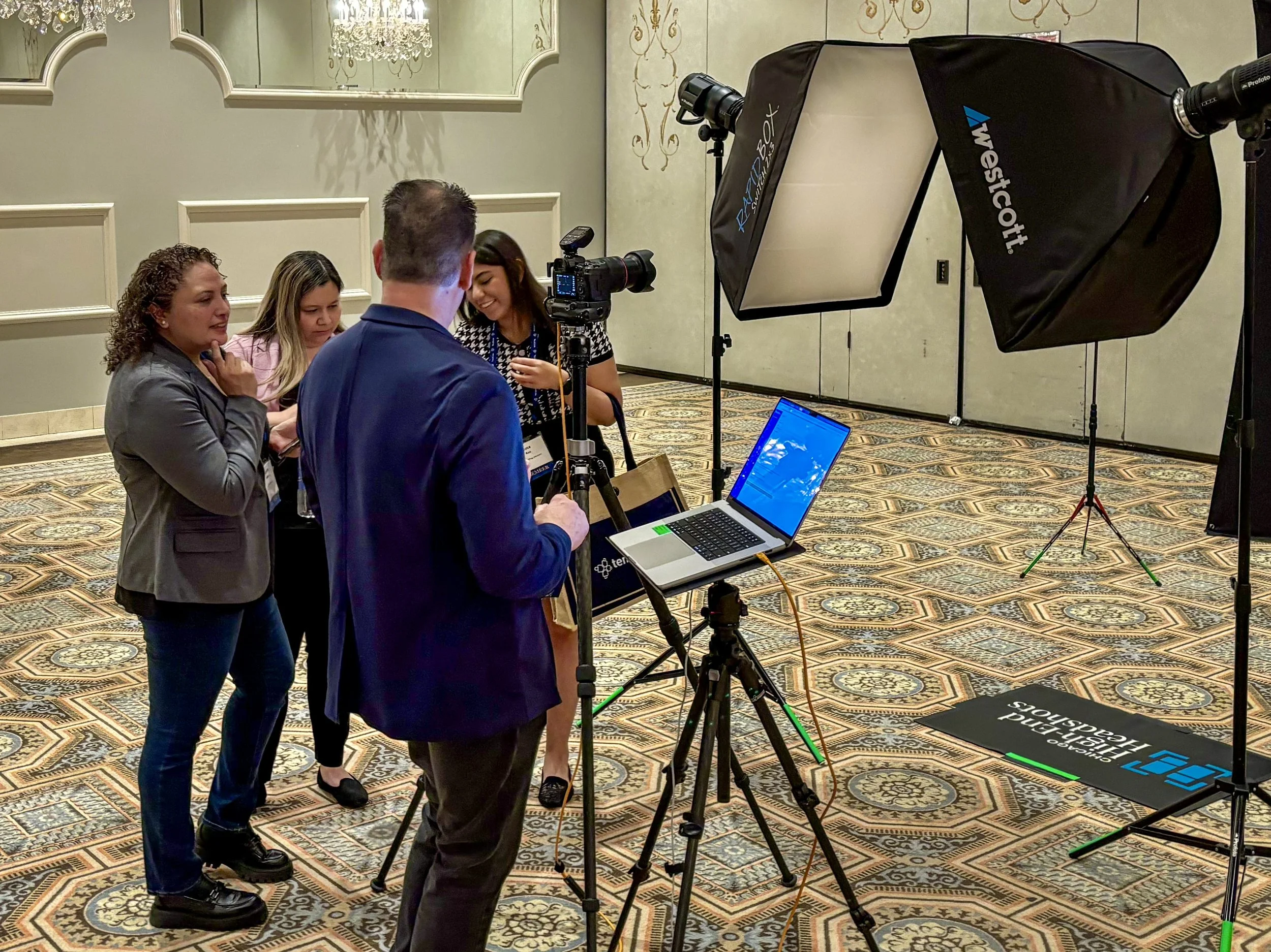 On-location corporate headshot production with professional lighting, tethered image review, and team members.