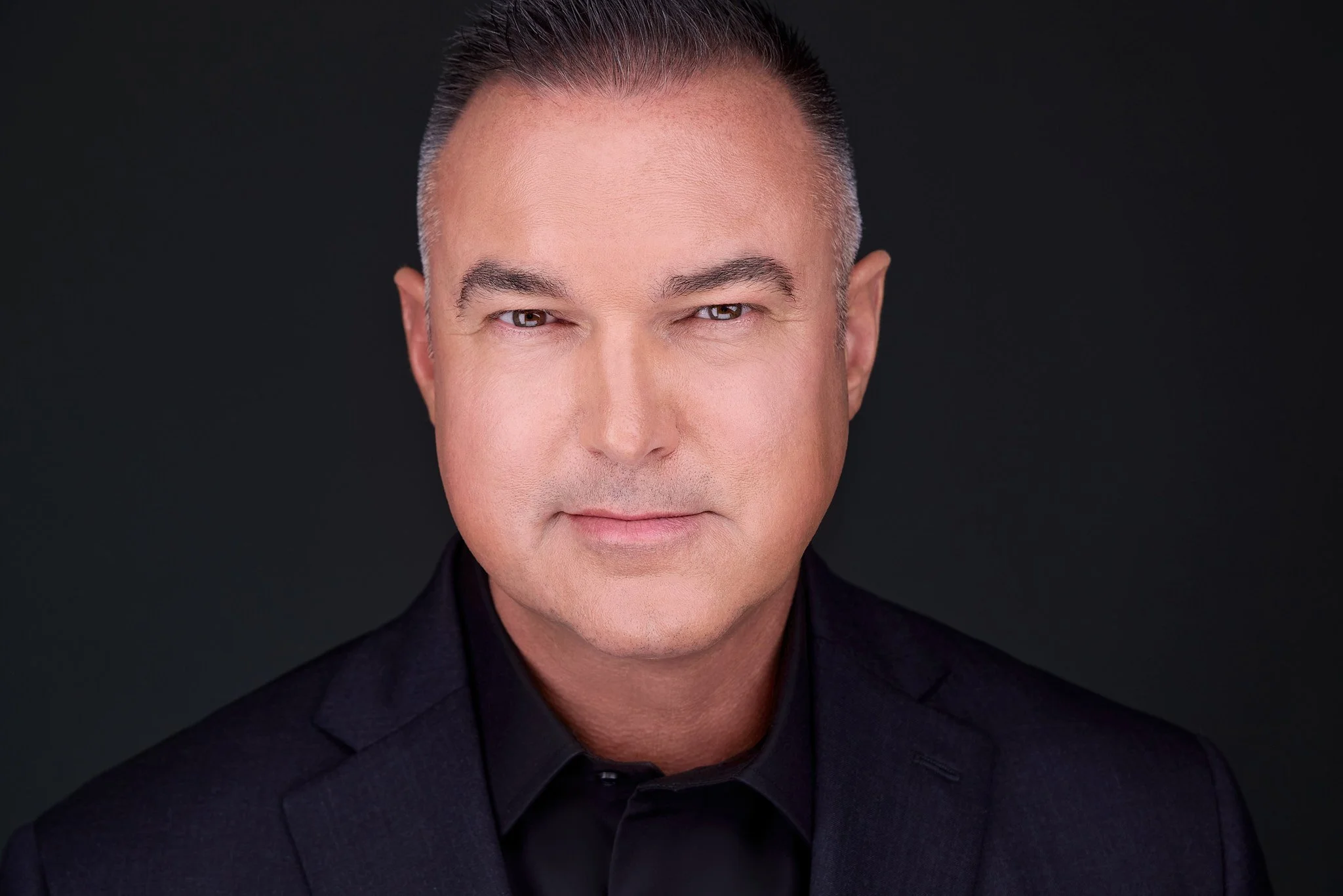 Executive headshot with a composed, confident expression.