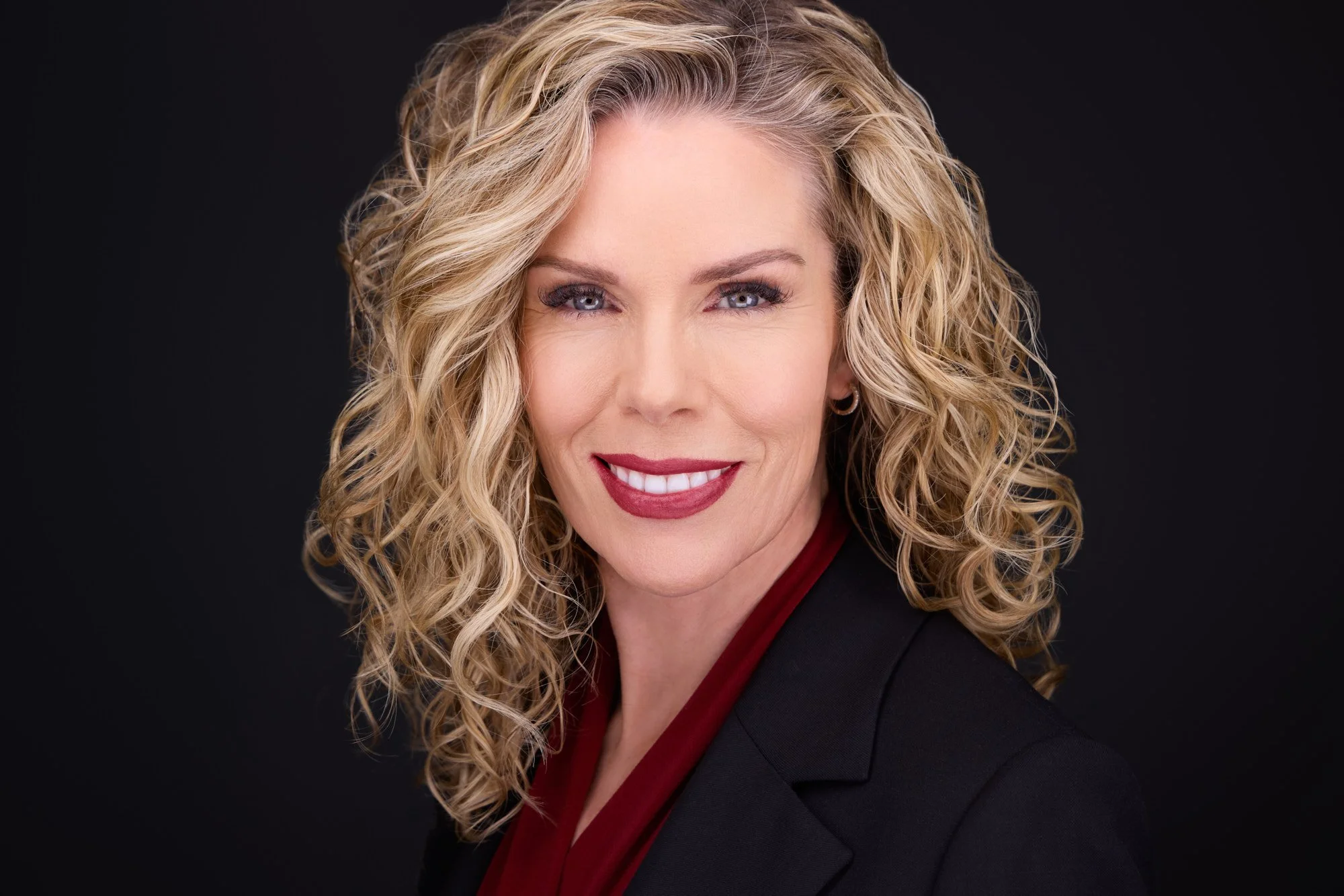 Professional headshot showing a balanced expression with subtle smile and composed posture.