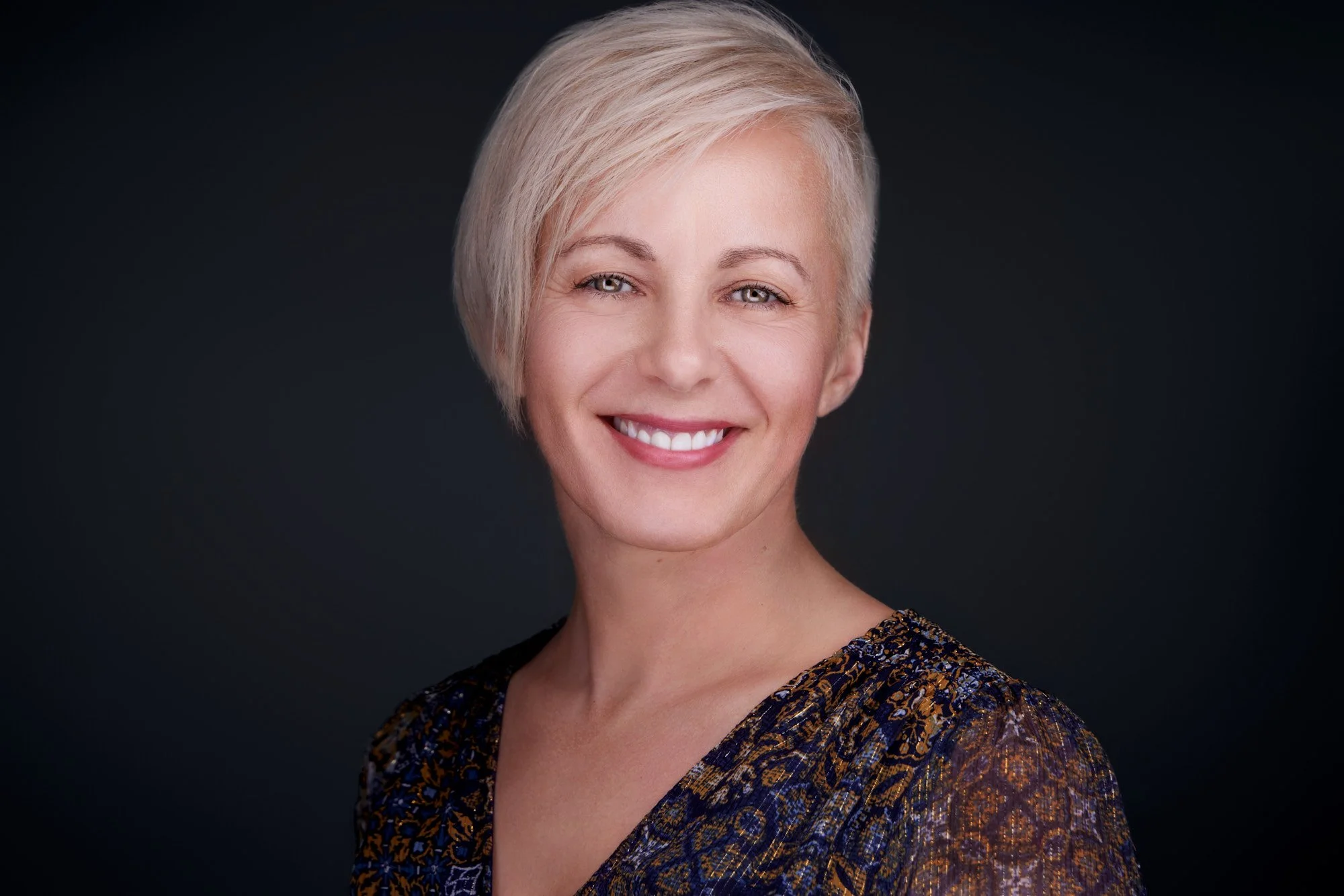 Professional being guided through facial expression coaching to achieve a relaxed, confident, and authentic expression during a headshot session.