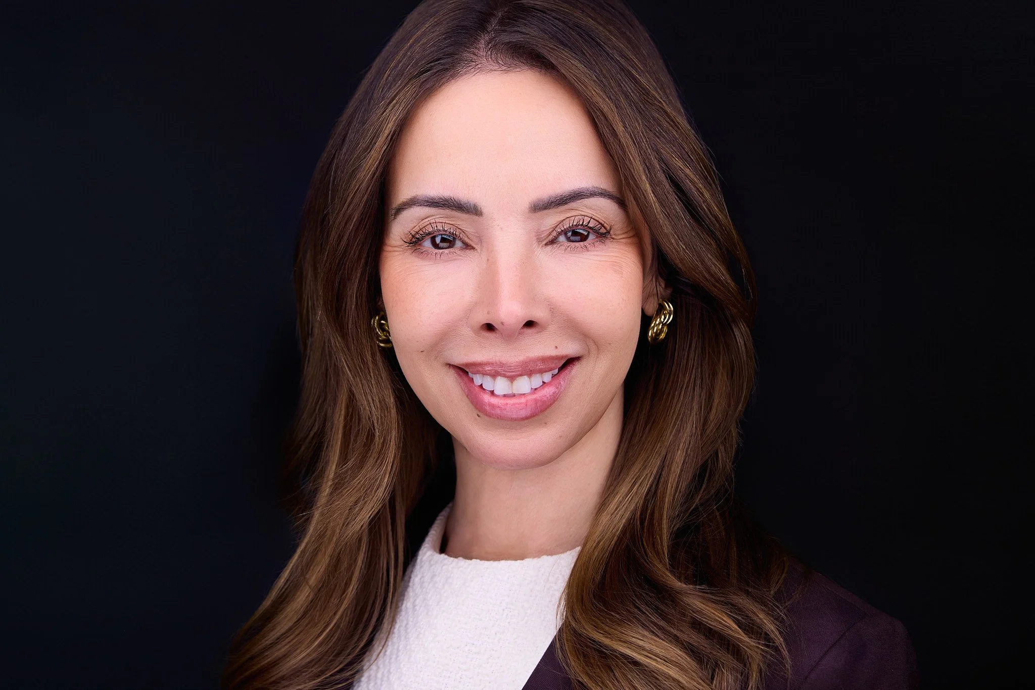 Executive headshot with a warm, professional expression.