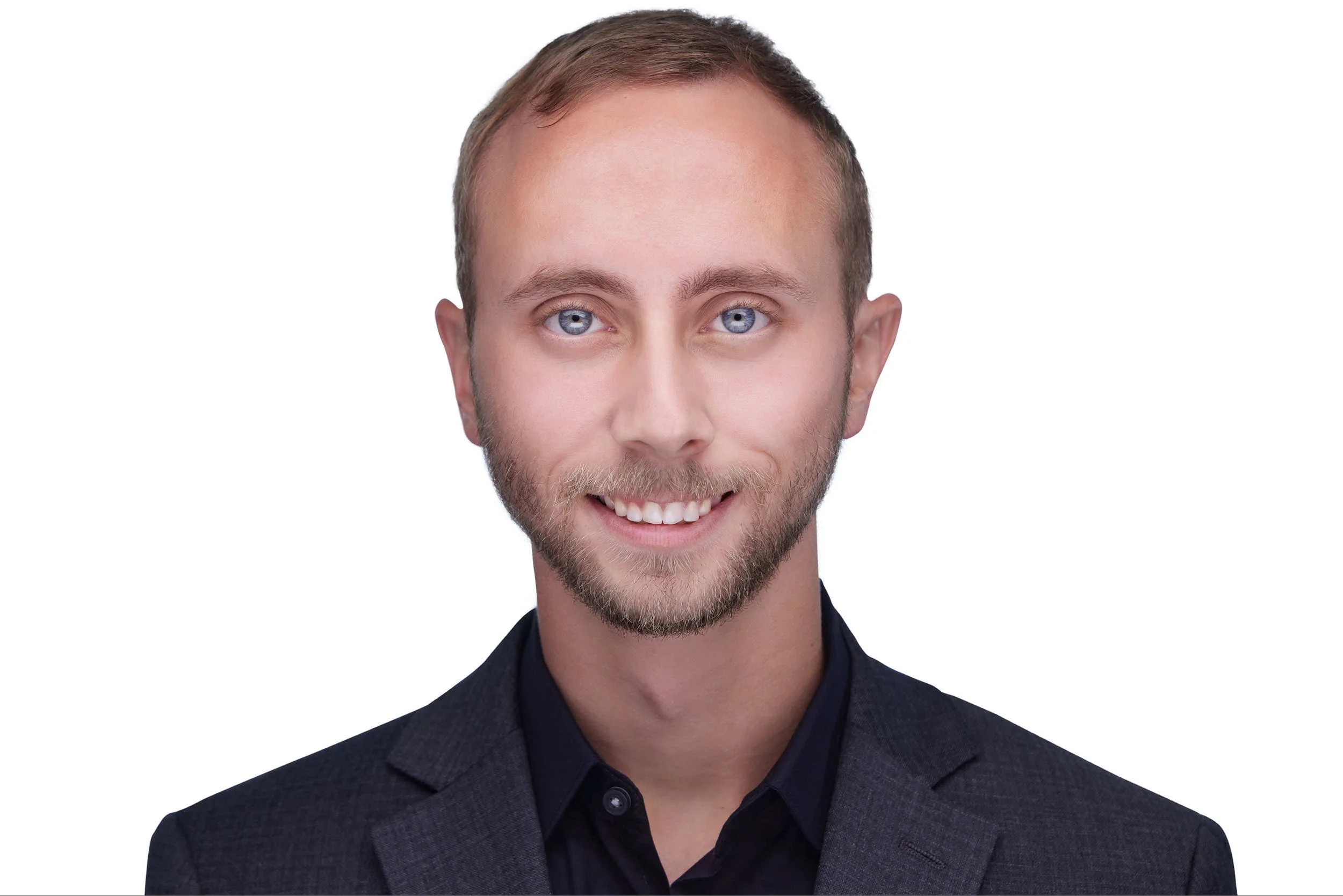 Professional headshot of a man in a dark blazer with a warm, approachable expression.