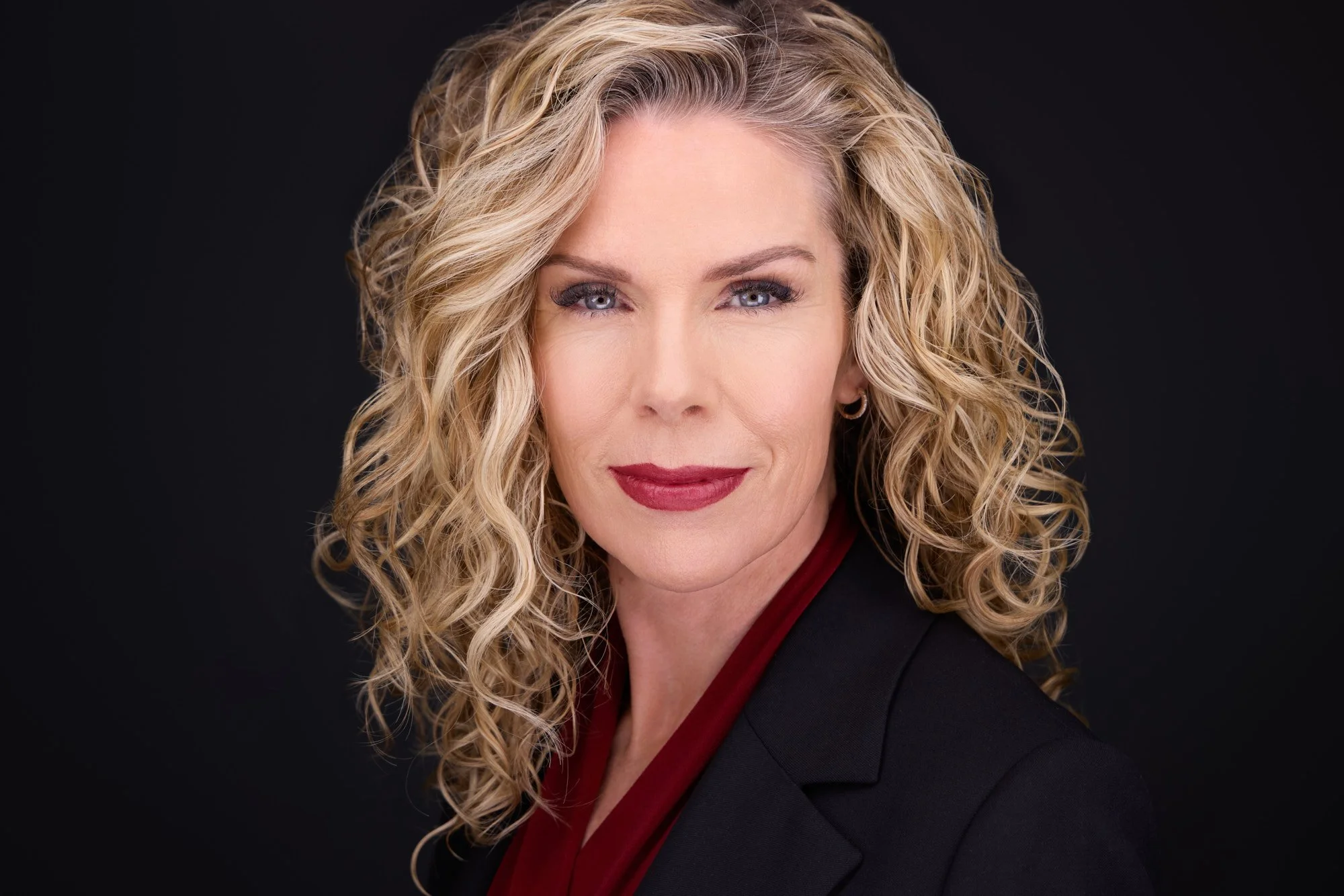 Professional headshot with a confident, composed expression demonstrating strong eye contact and presence.