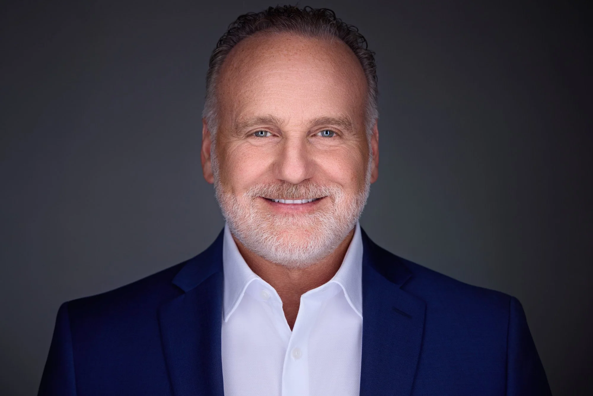 Facial expression coaching session guided a professional to a confident, approachable presence during a headshot session.