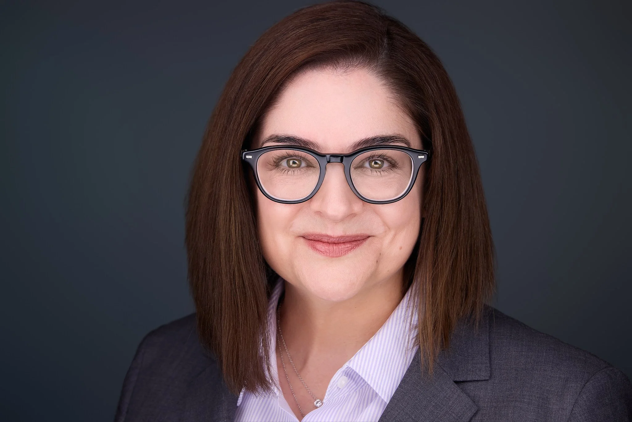 Professional with approachable yet confident expression in a headshot.