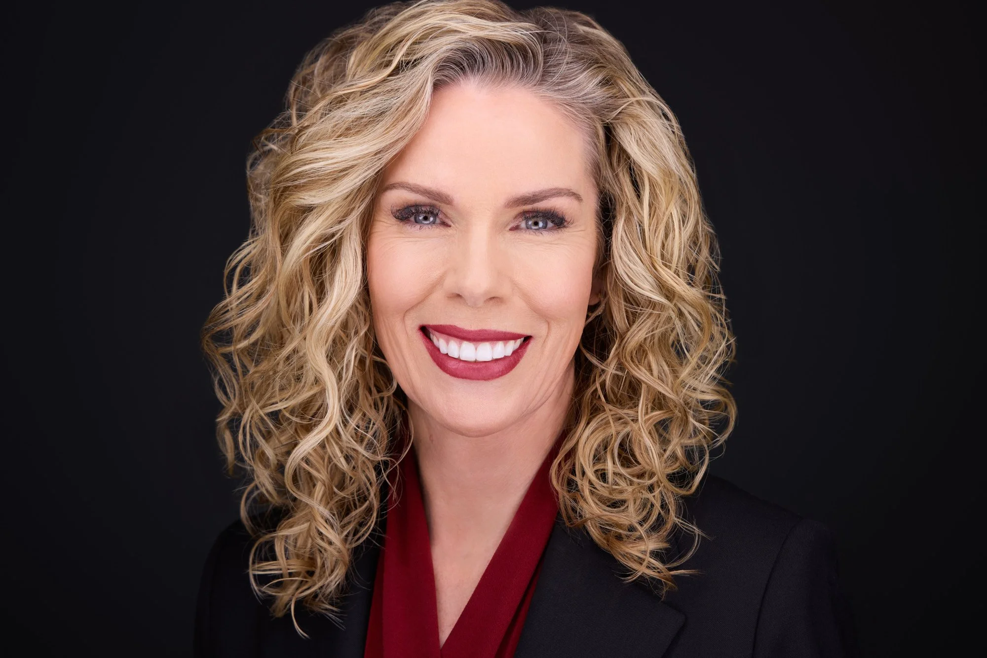 Professional headshot with a warm, approachable expression and natural smile.