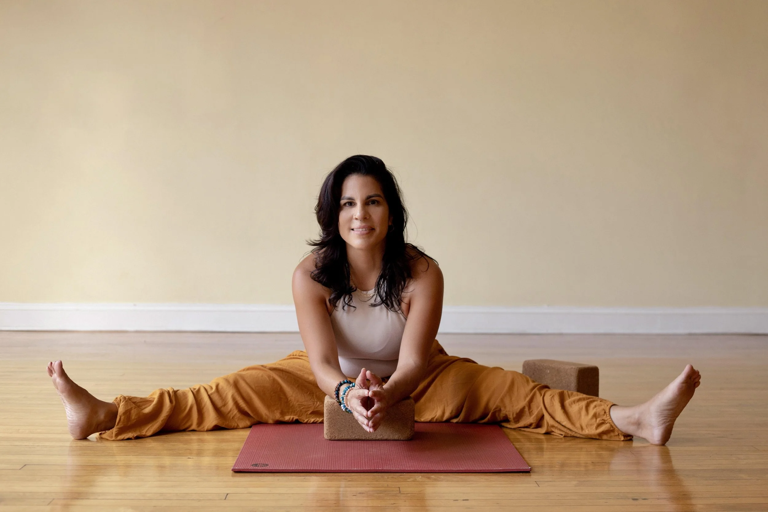 A woman smiling indoors on a yoga mat