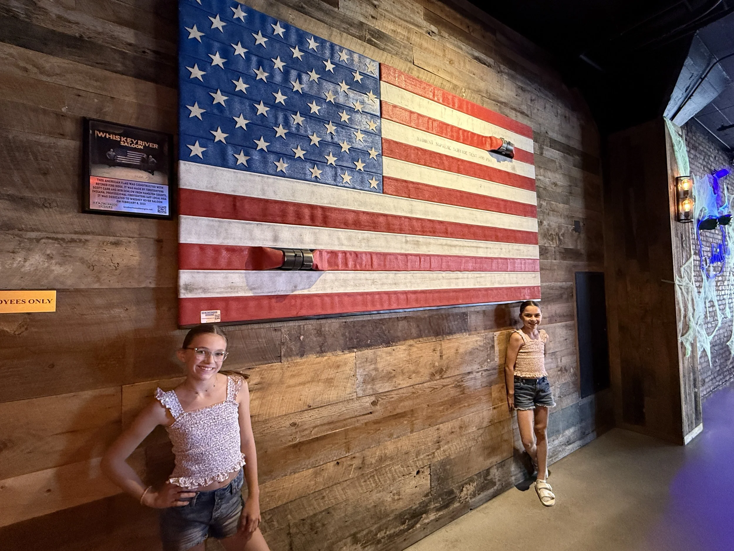 Brynn and Addison on Fall Break at Whiskey River Saloon with the Ladder Series flag