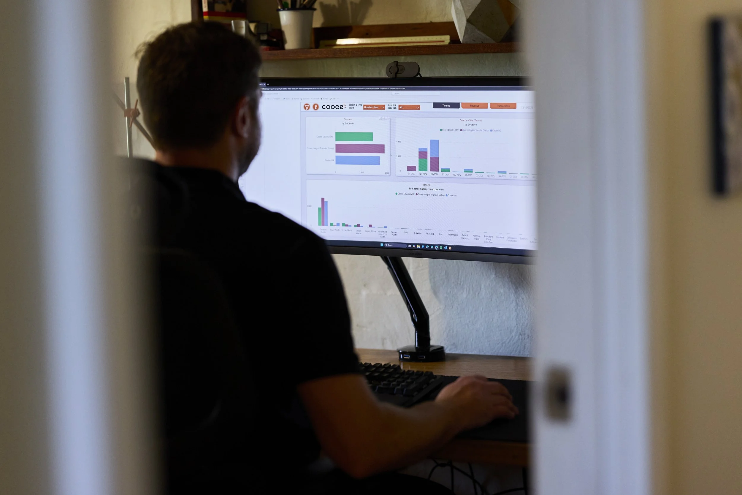 A man pulling waste data on his computer in an office