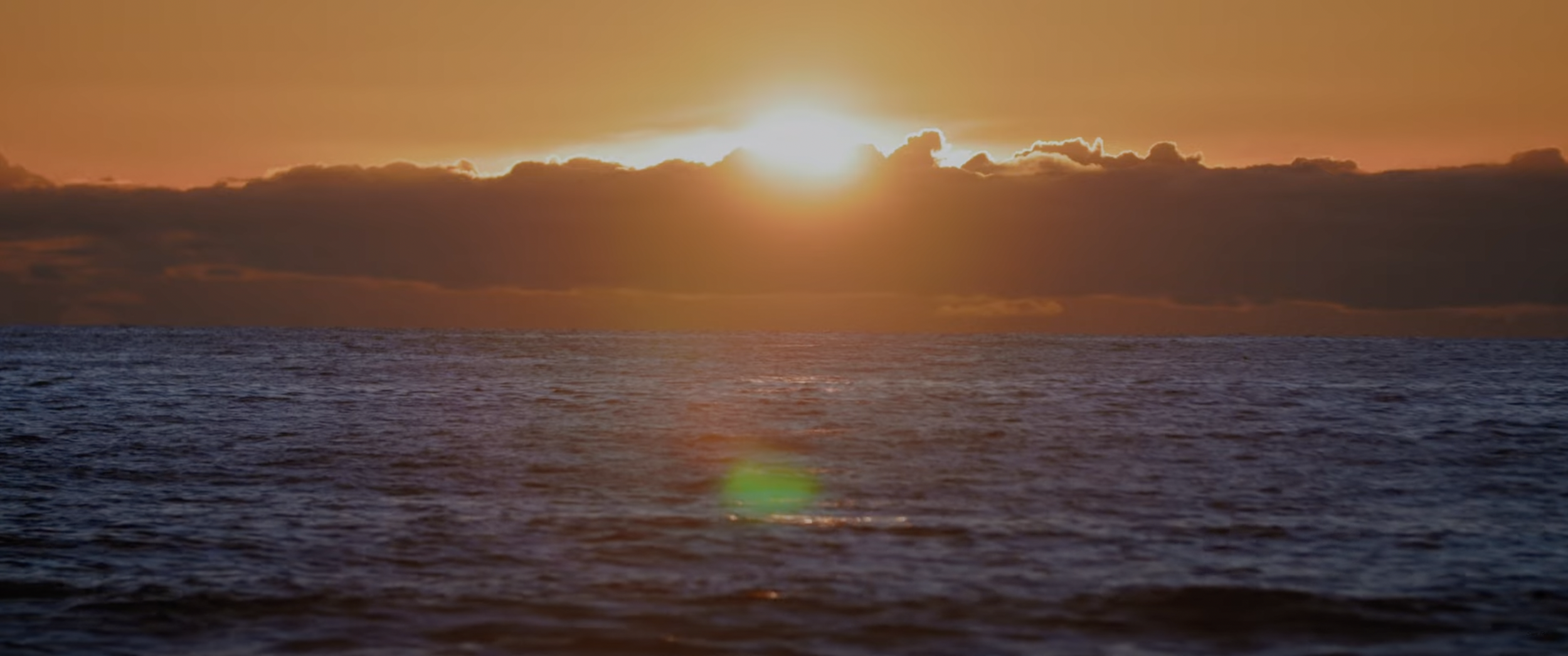 sunset over ocean with clouds and orange sky