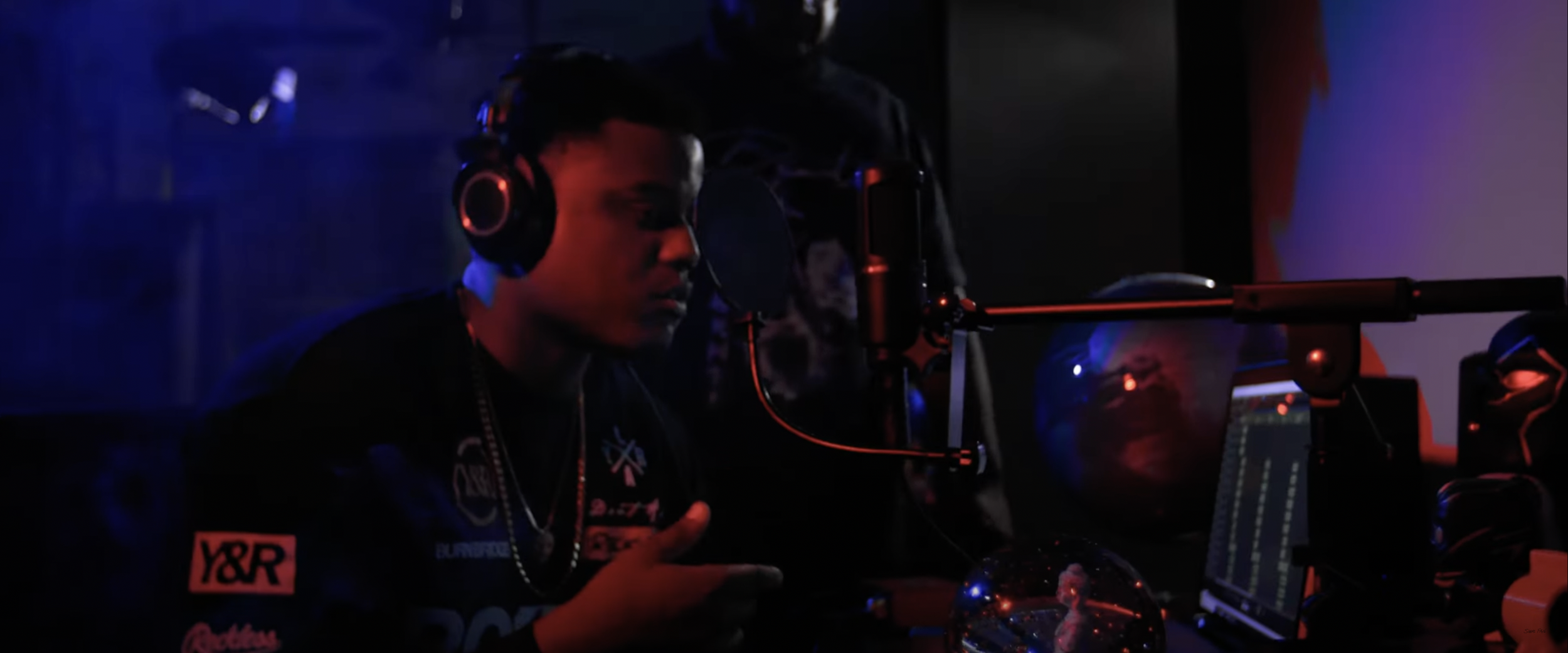 Person in recording studio with headphones and microphone