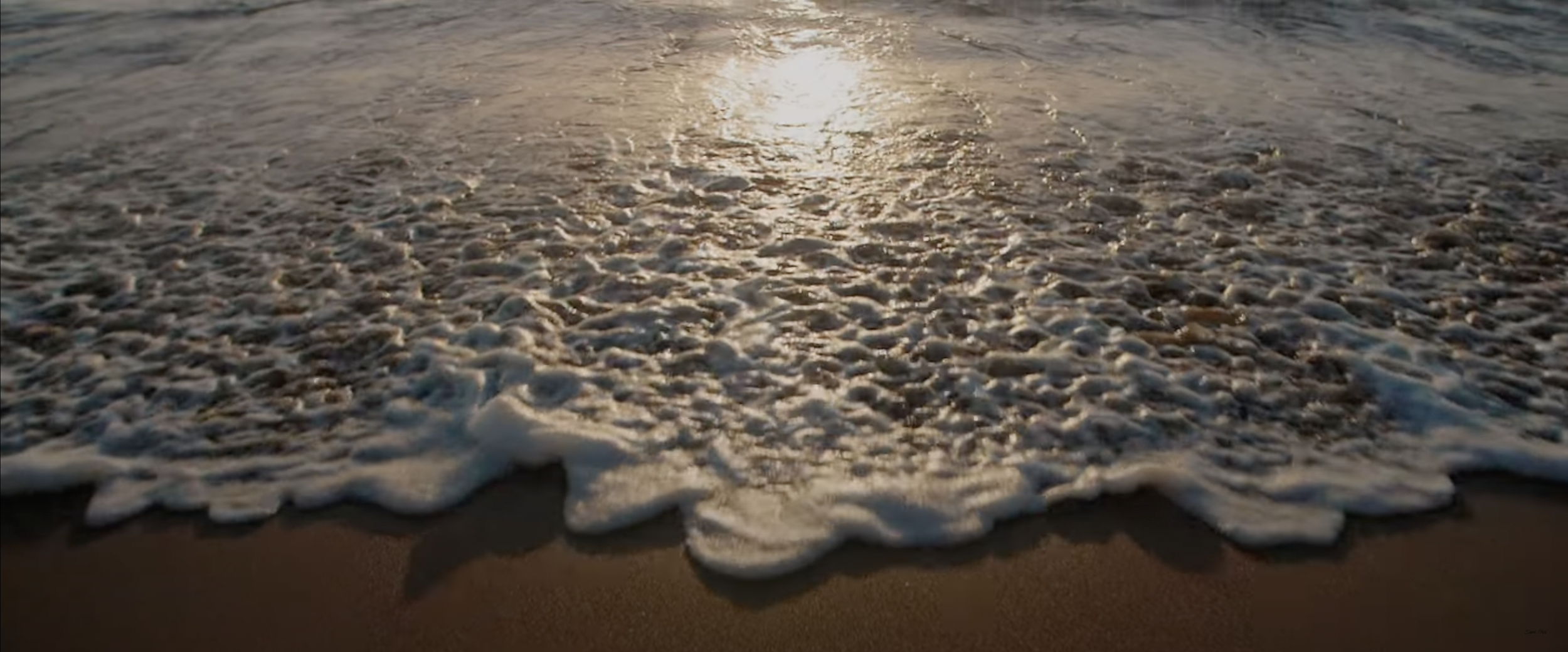 Beach waves with foamy surf at sunset