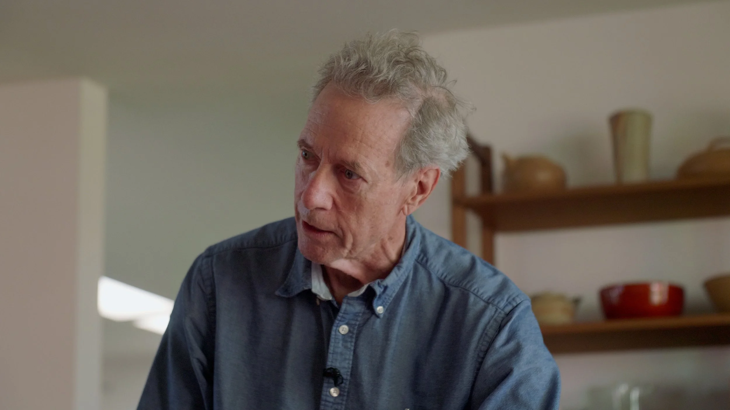 Older man in blue shirt in kitchen setting