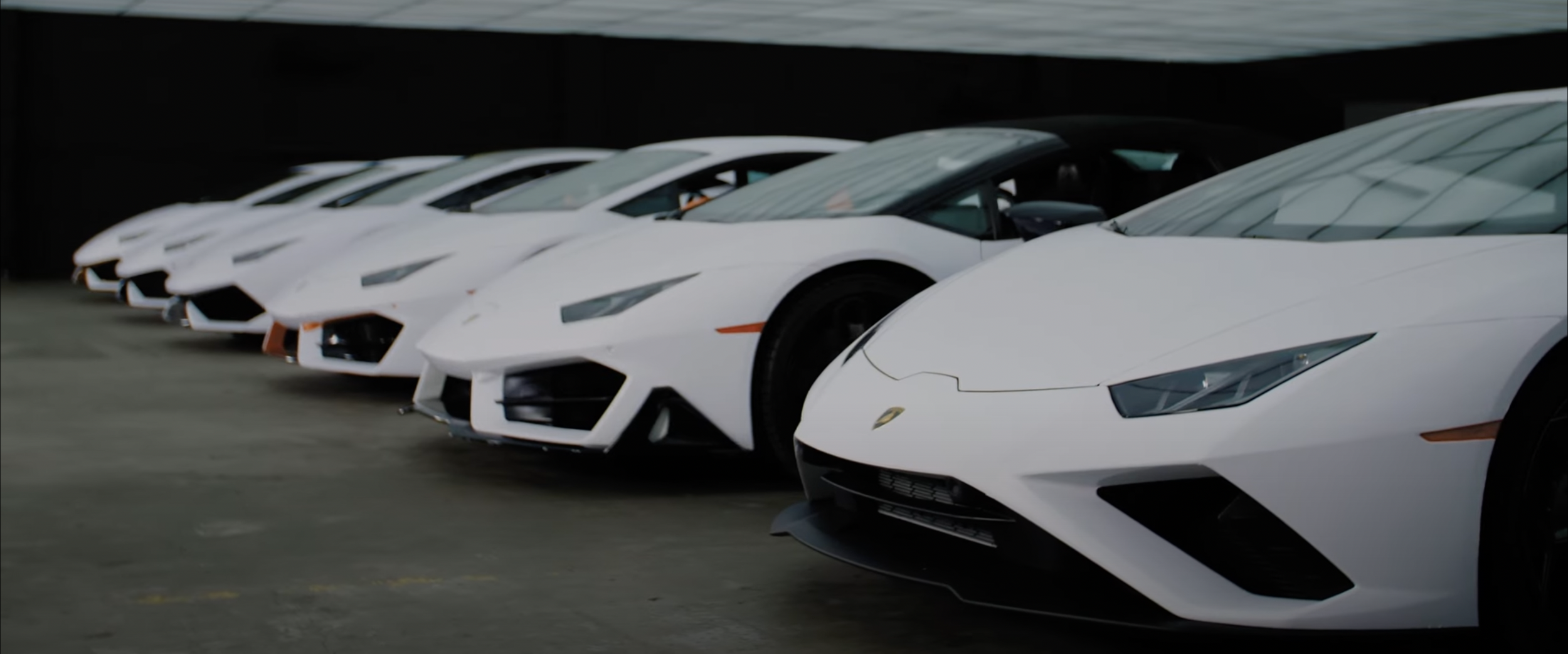 Row of white Lamborghini sports cars parked indoors