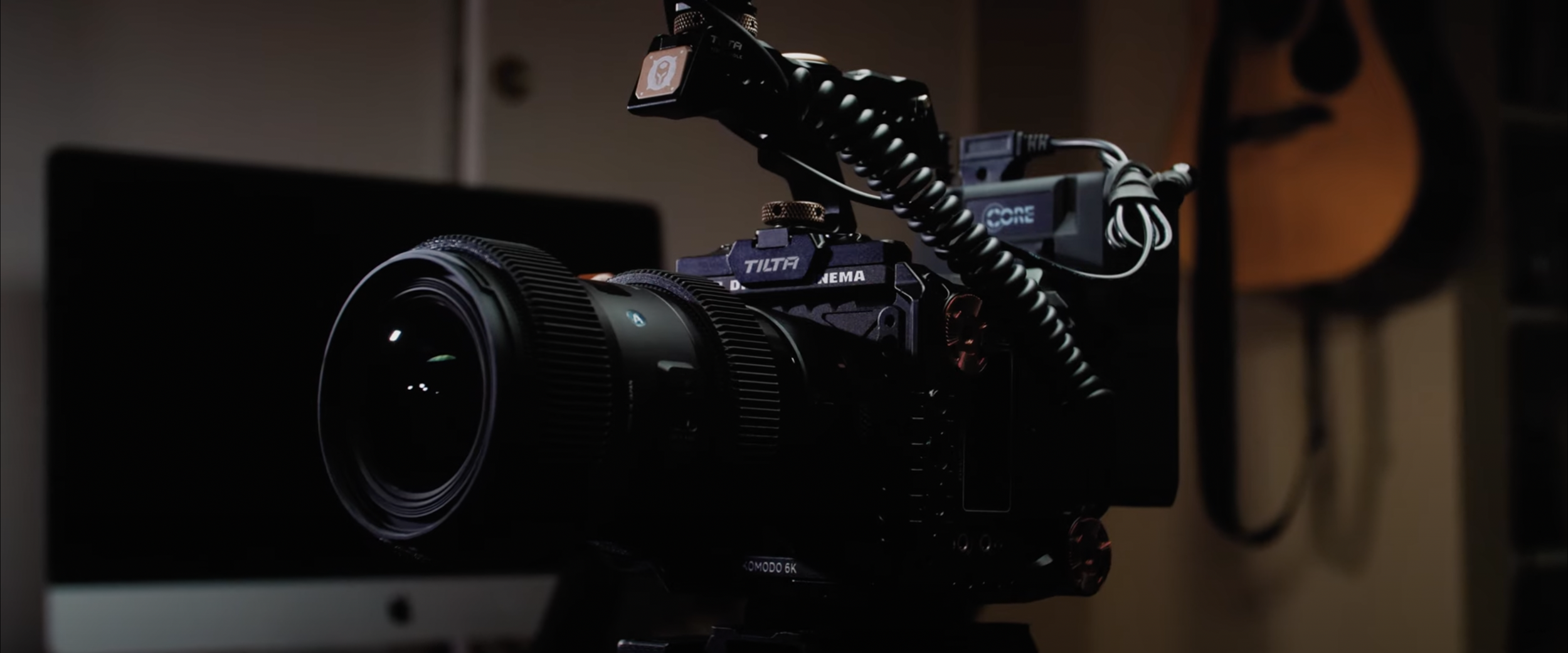 Close-up of a professional camera setup with a Tilta cage and accessories