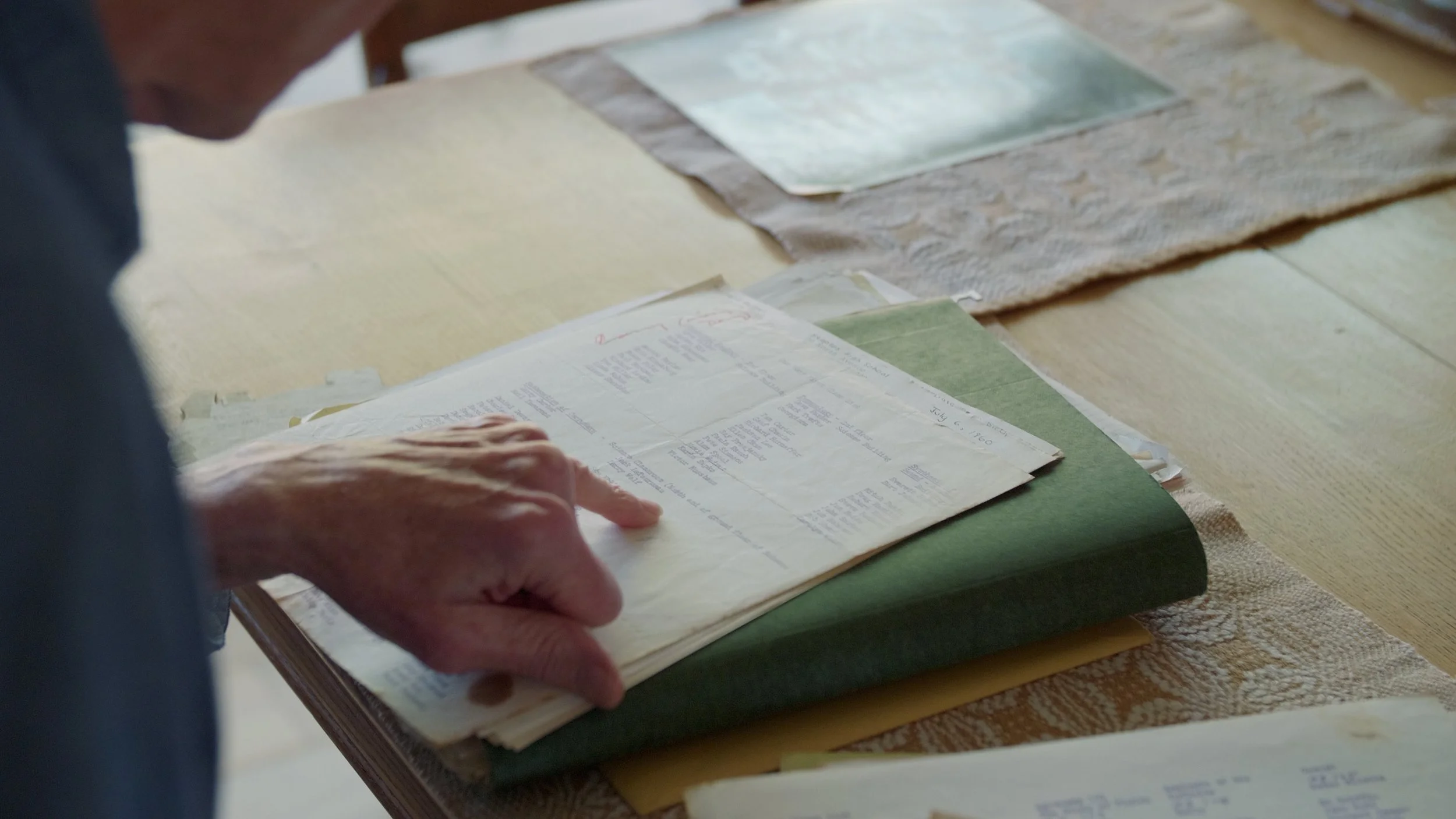 Person reviewing papers on a table with documents and folders