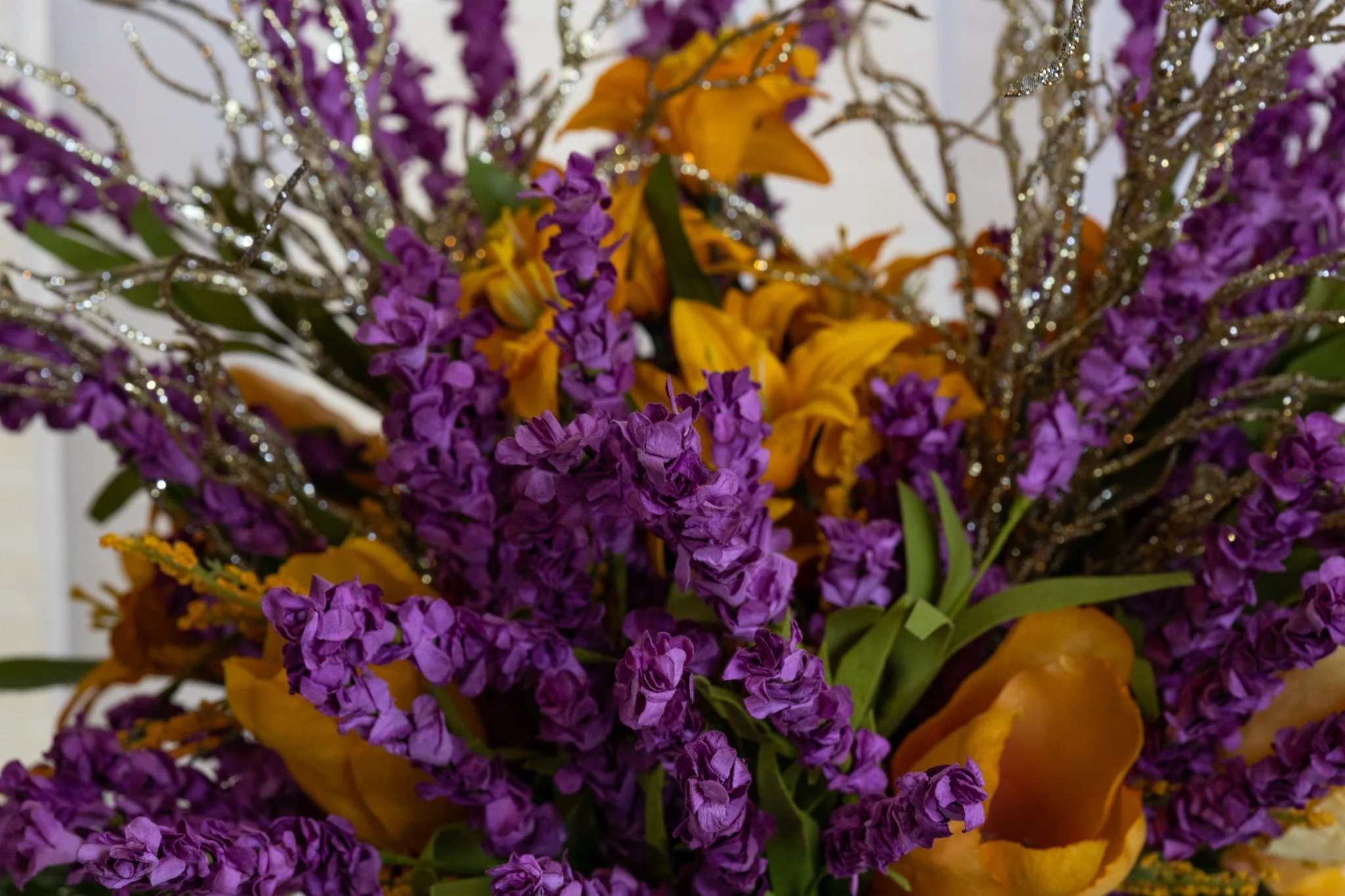 A bouquet of purple and yellow flowers with glittery accents.
