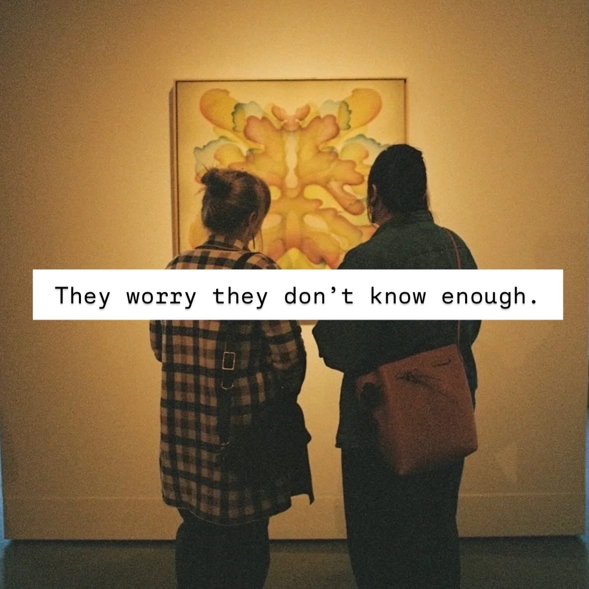 Two people are viewing an abstract yellow and green butterfly artwork in an art gallery. The text overlay reads, 'They worry they don’t know enough.'