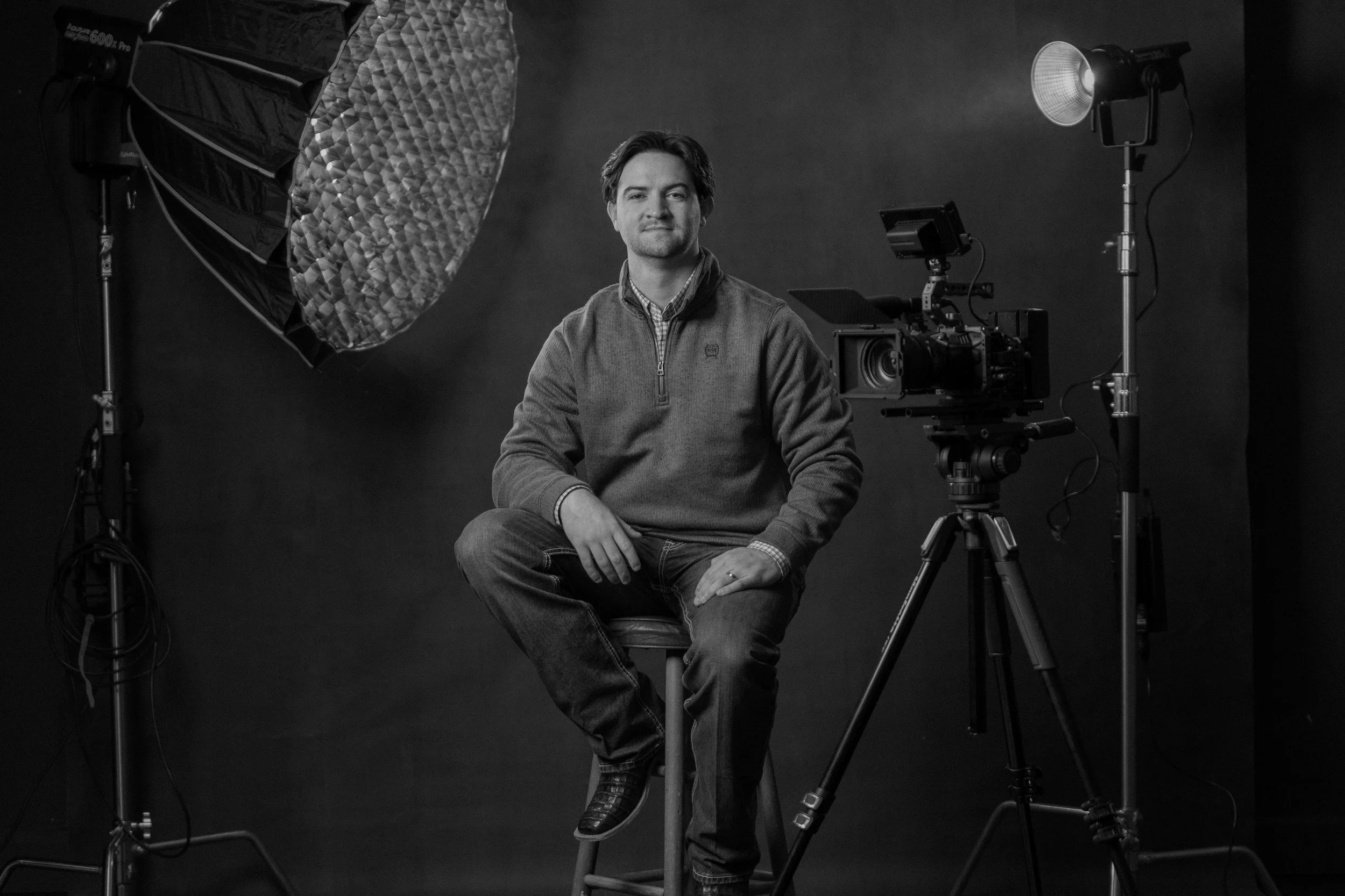 A portrait of a business owner. All of his video production gear surrounds him.