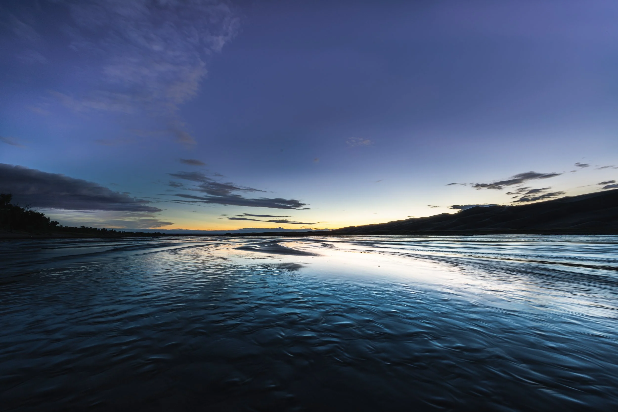 Twilight landscape with ocean waves reflecting colorful sky