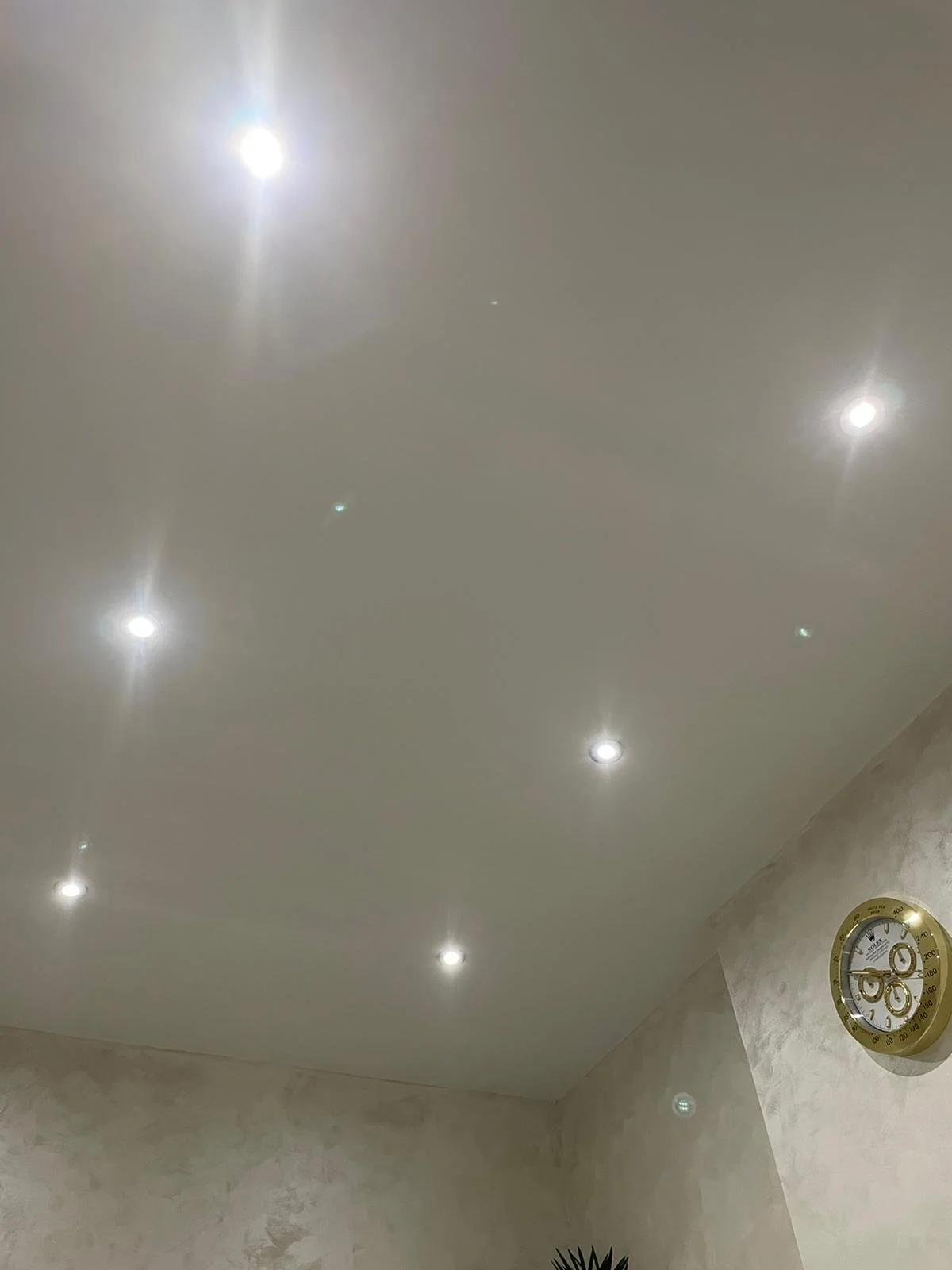 Ceiling with multiple recessed lights and a wall clock.
