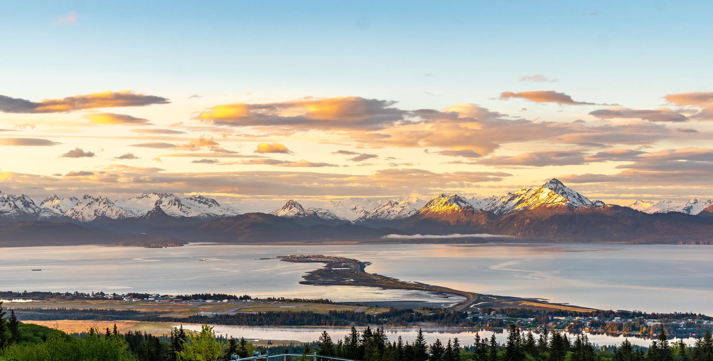 Scenic coastal view of Homer, Alaska at sunset with snow-capped mountains and Kachemak Bay, highlighting the location for mental health careers