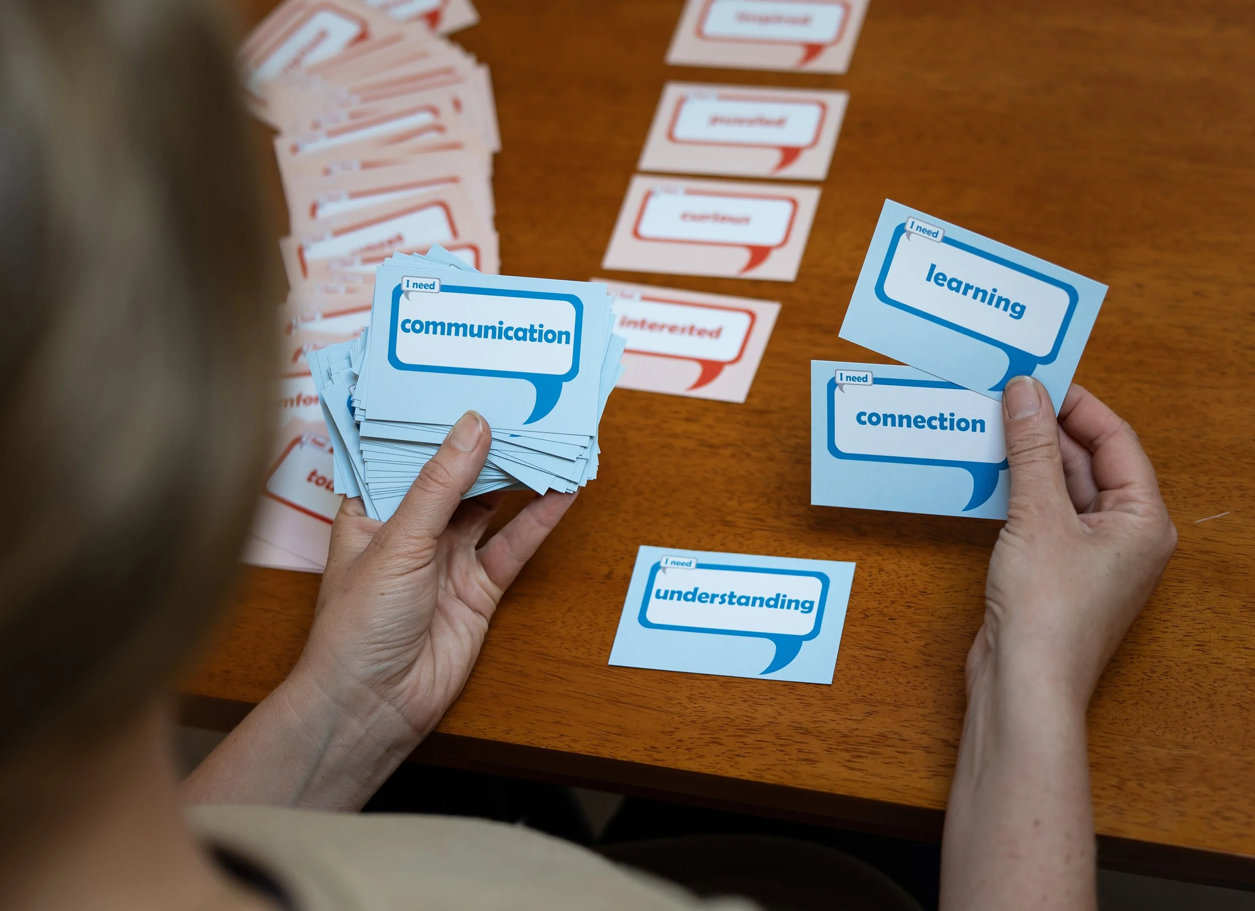 A person using cards showing feelings and needs.