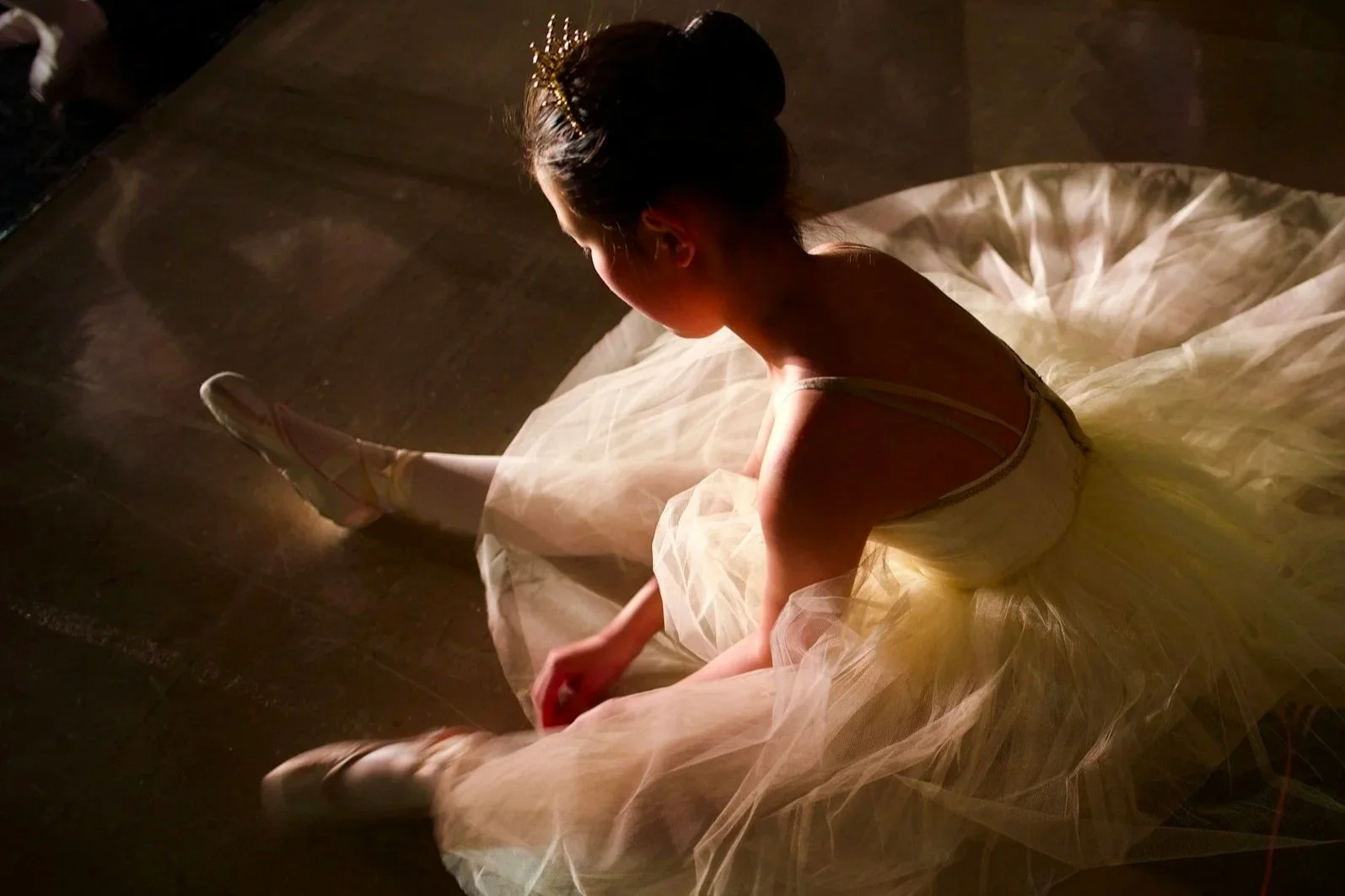 Bailarina de Ballet Clásico sentada en el piso concentrandose
