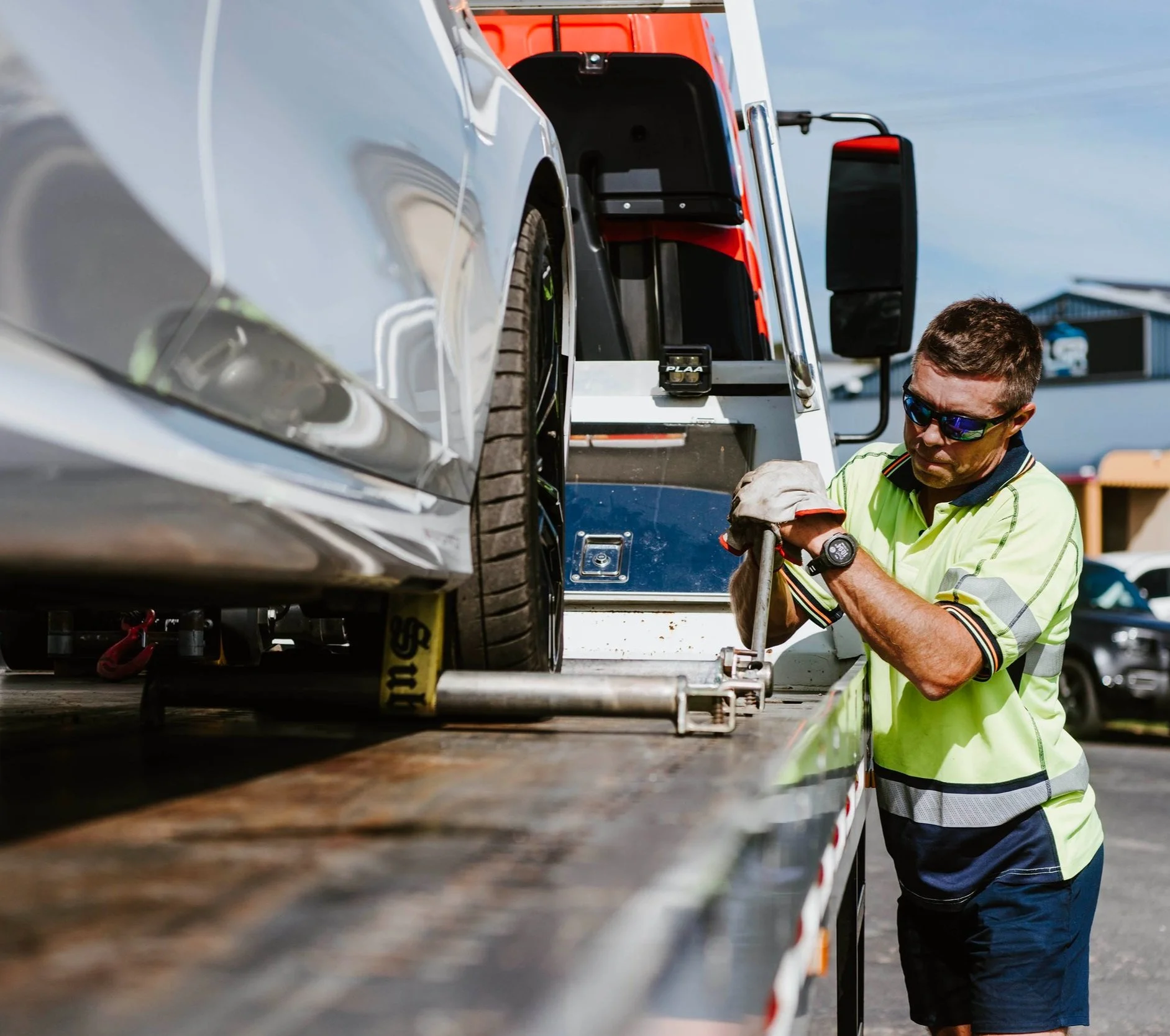 Tow truck driver loading 3 cars on a Car Carrier