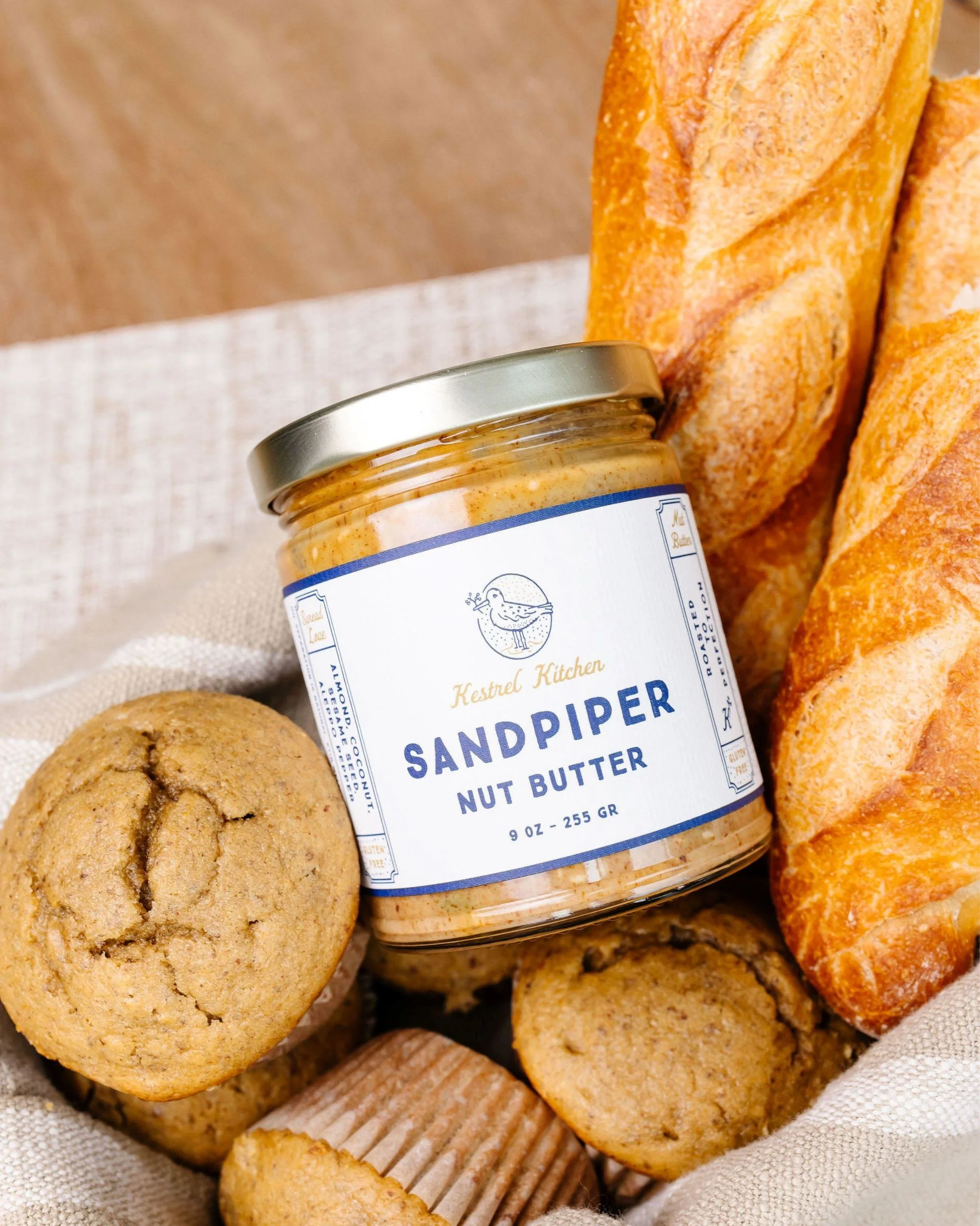 almond coconut nut butter served with muffins and sliced bread in a basket