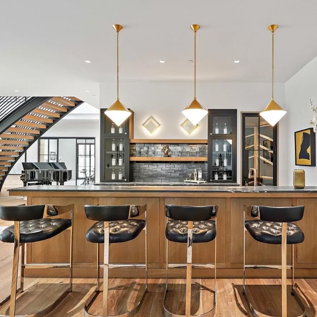 Gorgeous transitional home wet bar design at our project in Los Altos hills. The moody countertops paired with the rift white oak shelves and black cabinetry make for a clean and sophisticated space. These gorgeous  @mcgeeandco pendant lights give th