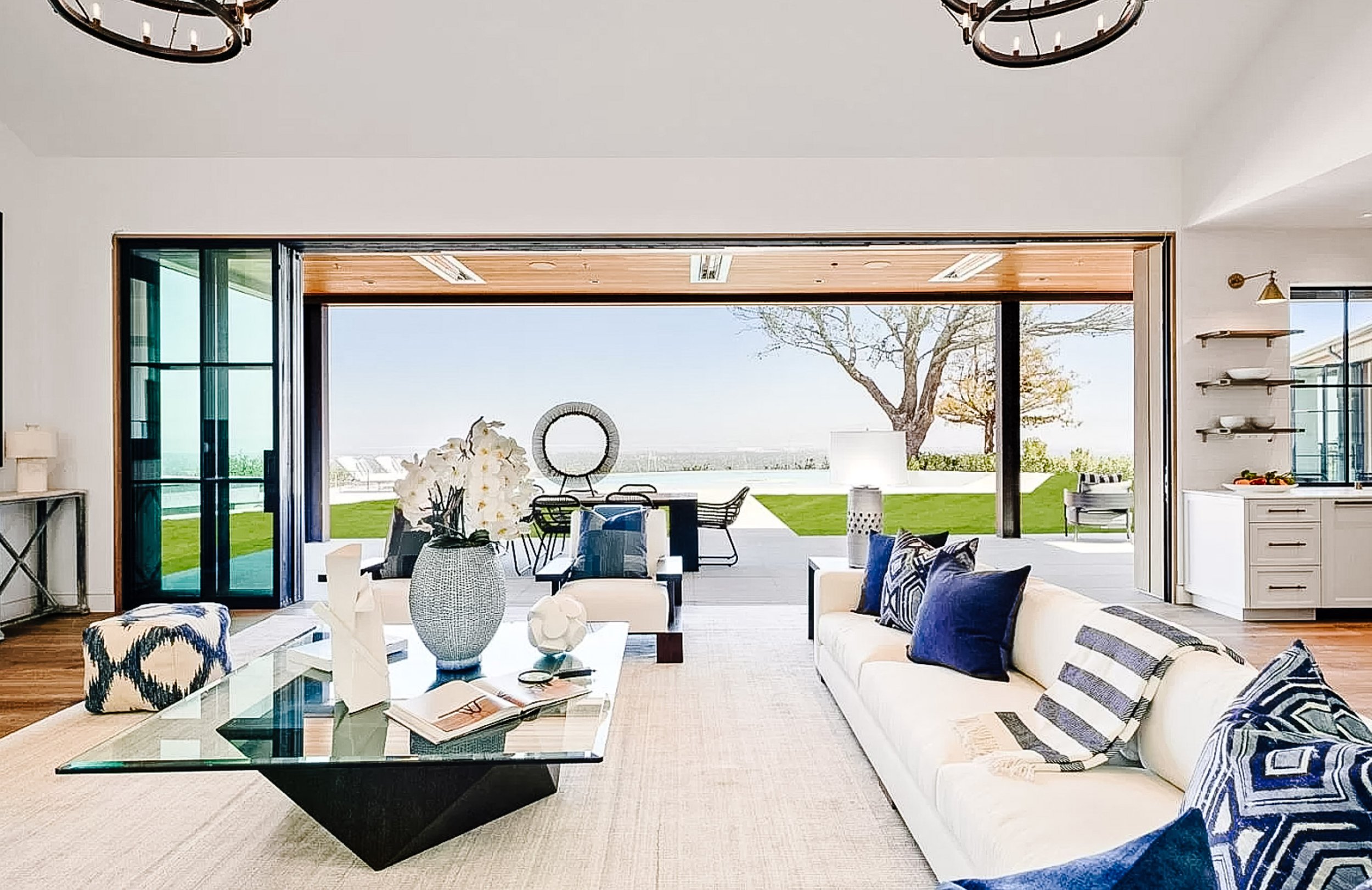 Spacious living room takes full advantage of the Bay views; a gas-log fireplace is flanked by double French doors to a covered and heated terrace with fireplace and media