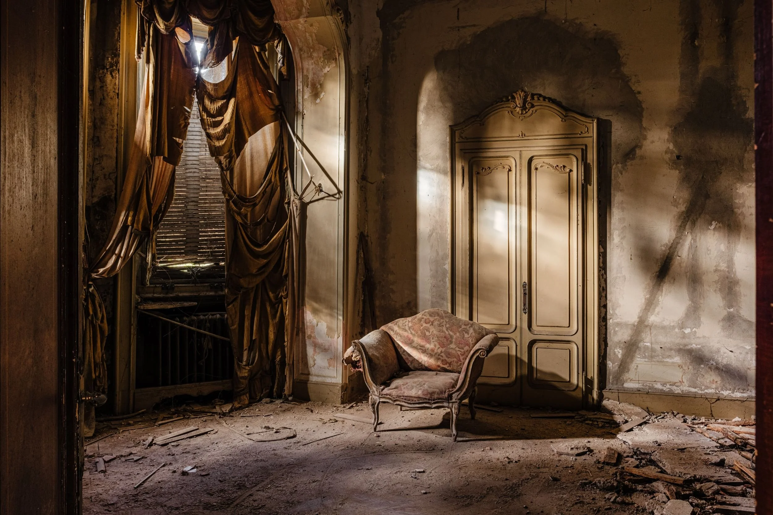An abandoned room in half-light, torn curtains and an empty armchair