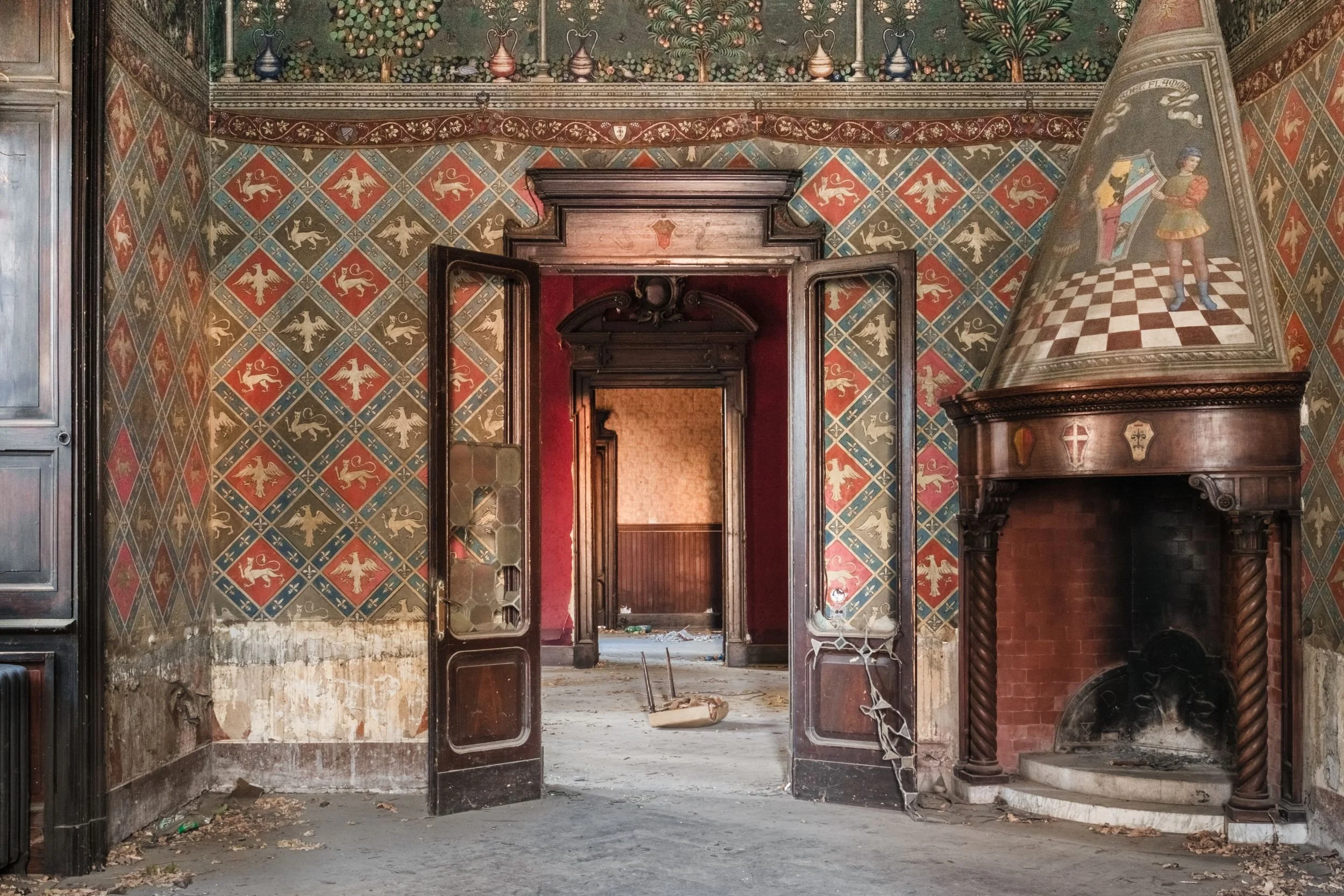 A room of painted tiles, open doors and a tall fireplace