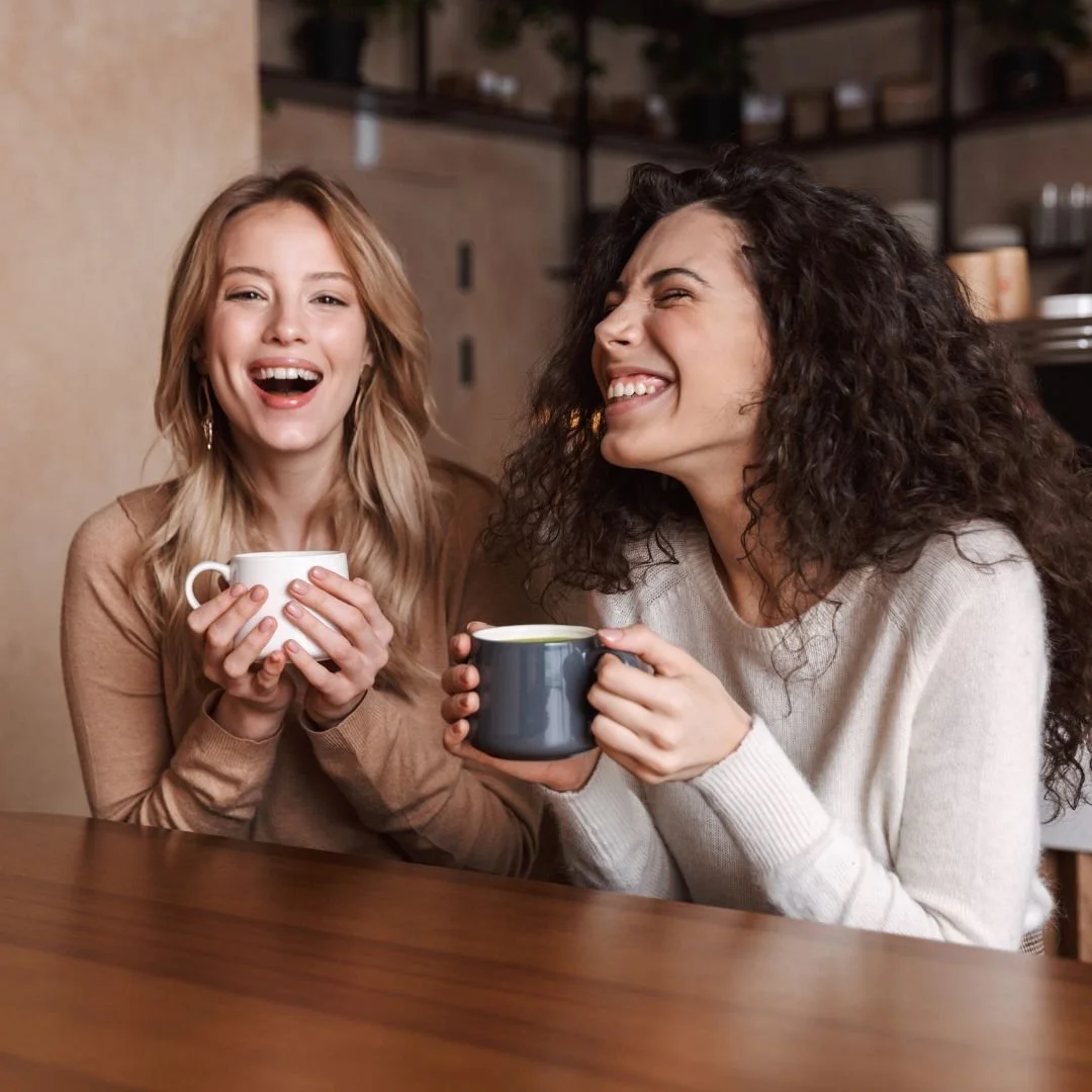 Friends smiling over coffee at a cafe