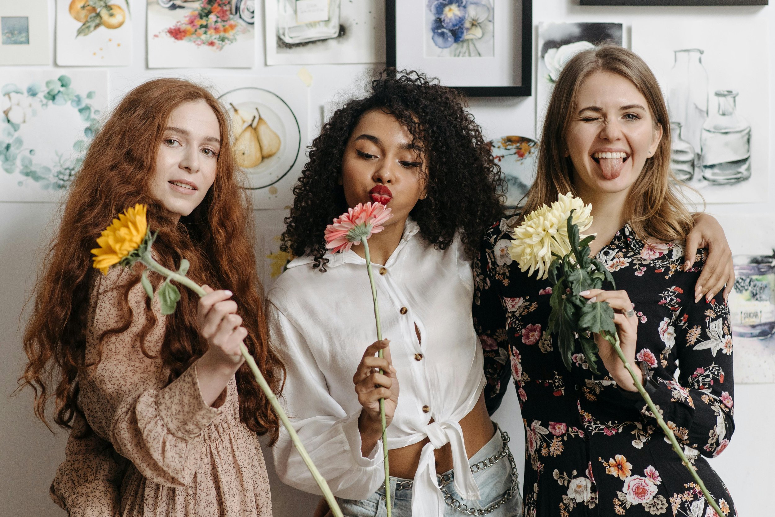 Three women friends smelling flowers