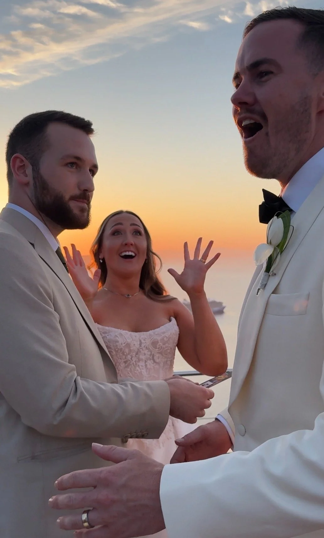 Destination Wedding Magician is doing a magic trick for the bride and groom in front of the sunset