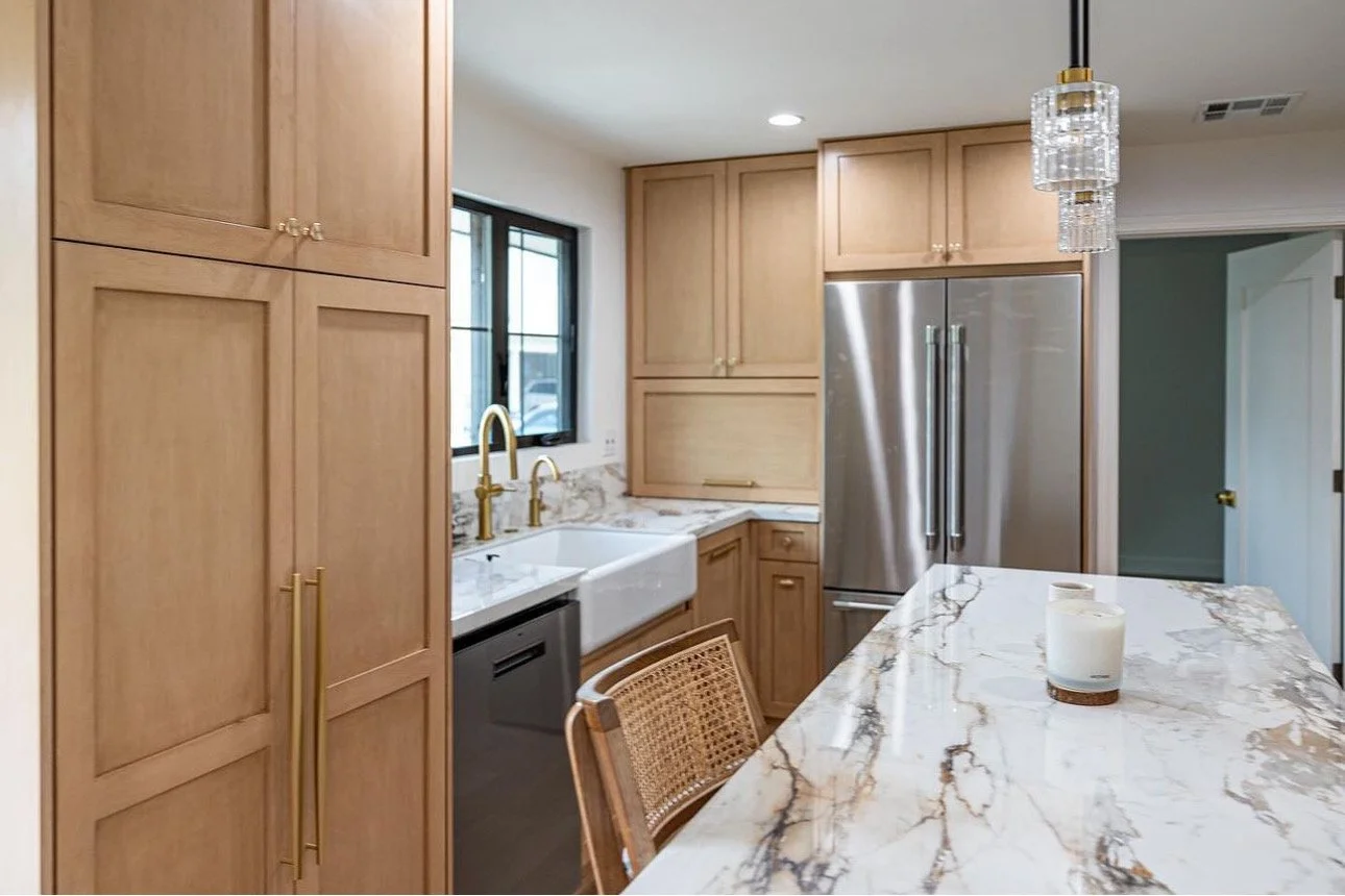 Modern kitchen renovation with custom wood cabinetry, marble waterfall island, stainless steel appliances, and recessed lighting.