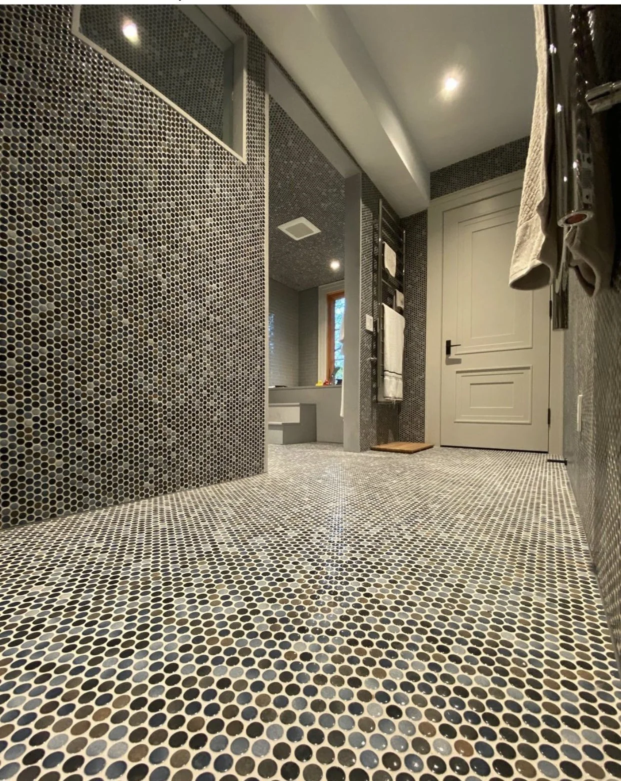 Bathroom remodel with custom penny tile flooring and walls, walk-in shower, and modern finishes