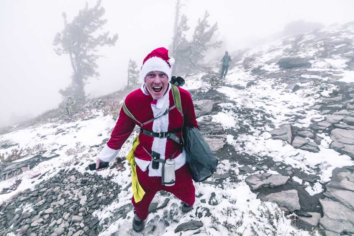  A runner dressed in a santa claus outfit emerges out of a snowy, low visibility scene 