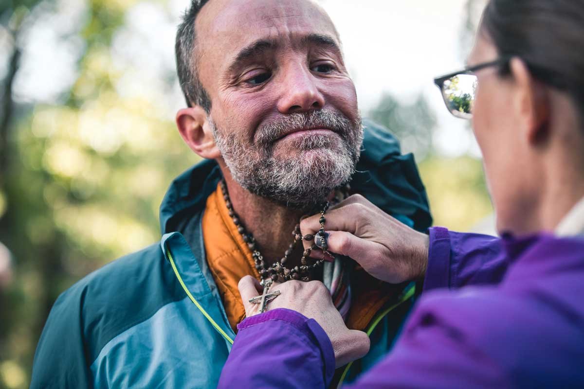  A touching moment between a runner and his crew as she adjusts his necklace 