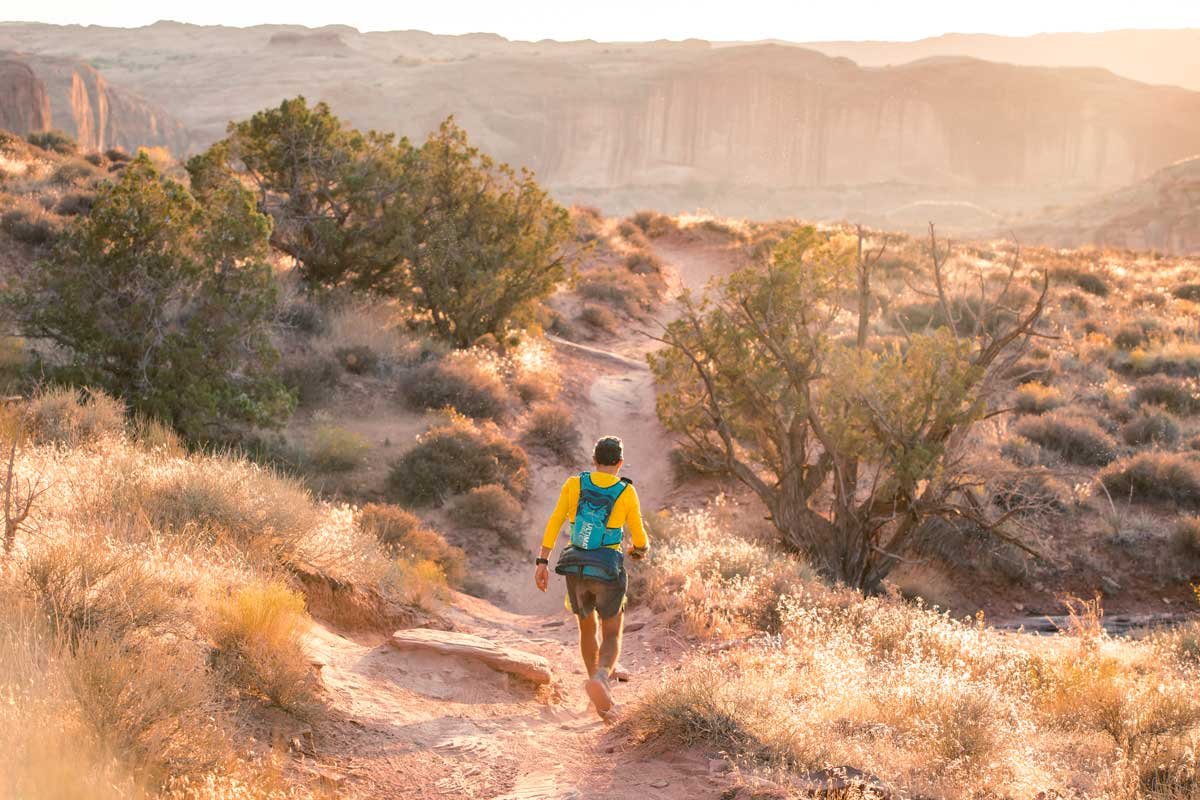  Golden light on the desert trails as a runner hikes by 