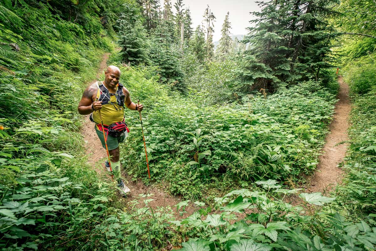  Male runner on a lush green singletrack trail in the pacific northwest 