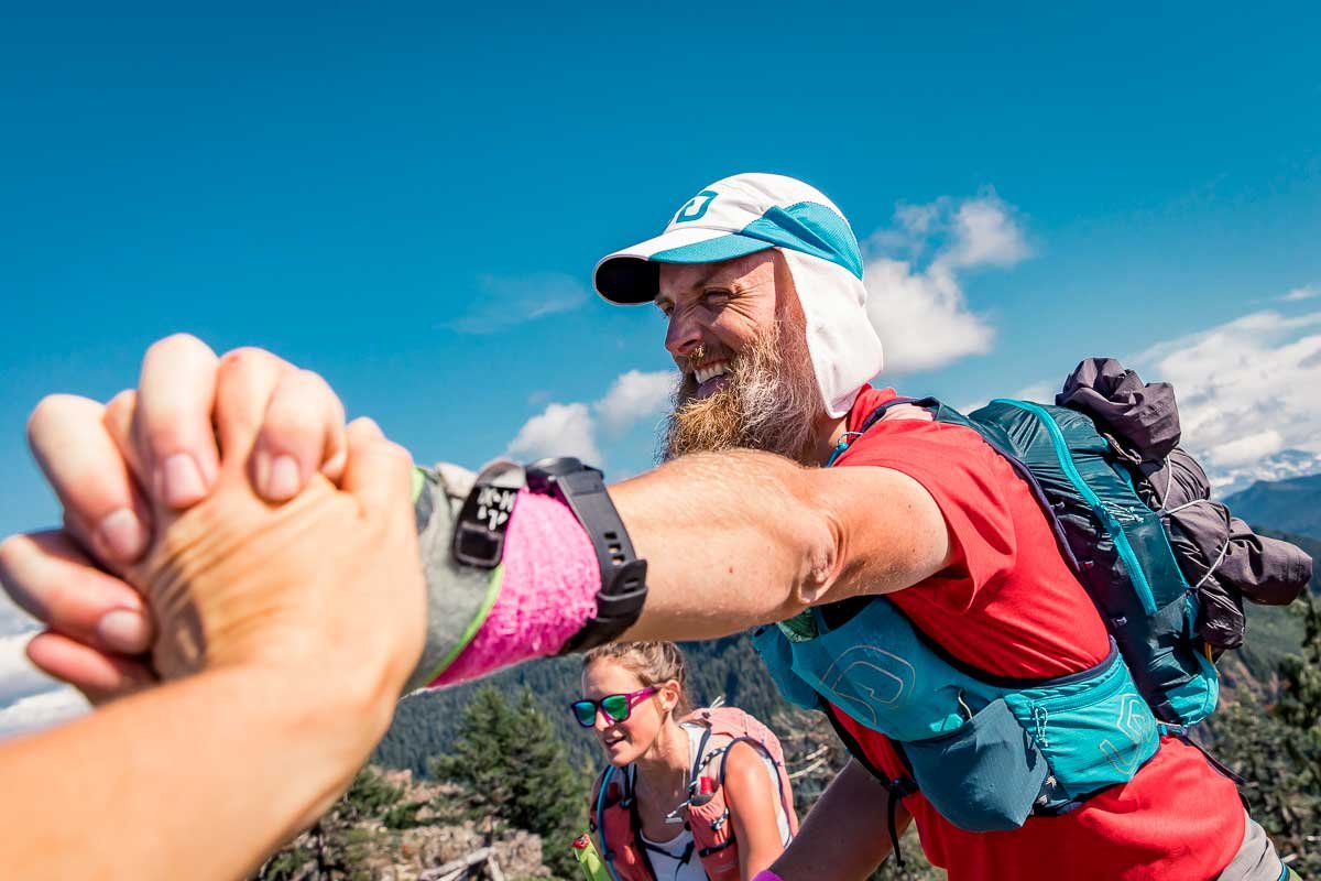  Male runner giving a high five and celebrating at the top of the last summit of Bigfoot 200 