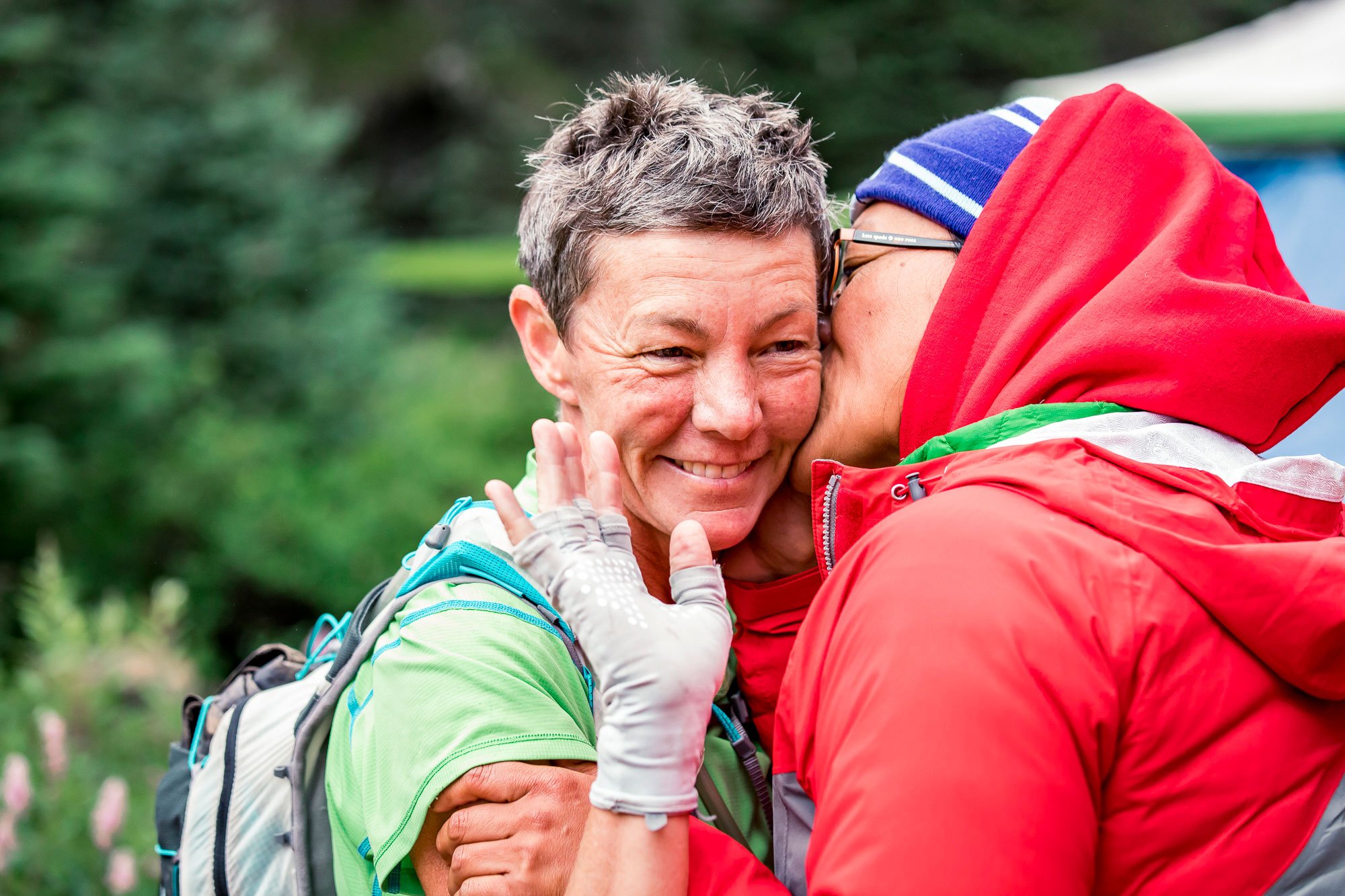  A runner being hugged by her crew at an aid station 
