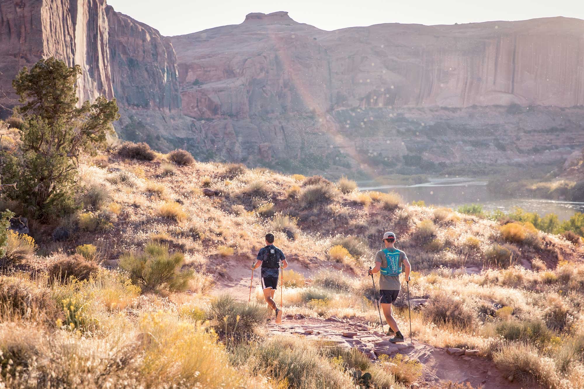  Two runners make their way through Porcupine Rim in Utah during golden hour 